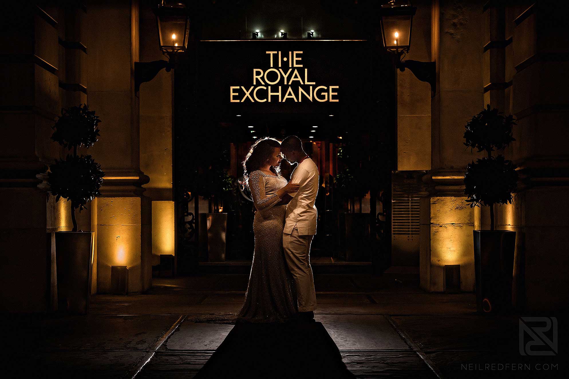 night time photograph of bride and groom outside The Royal Exchange London
