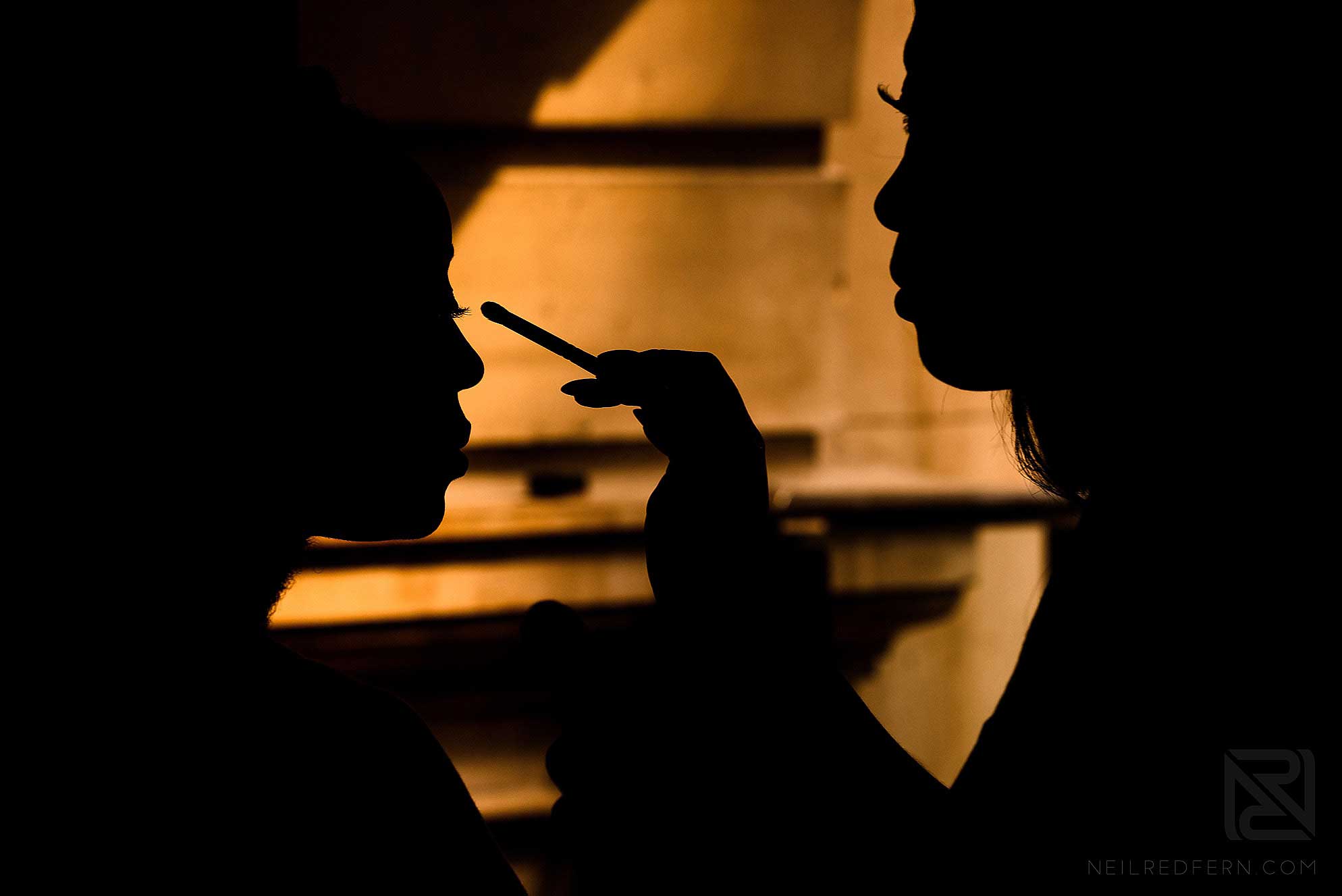 silhouette photograph of bride having make-up put on