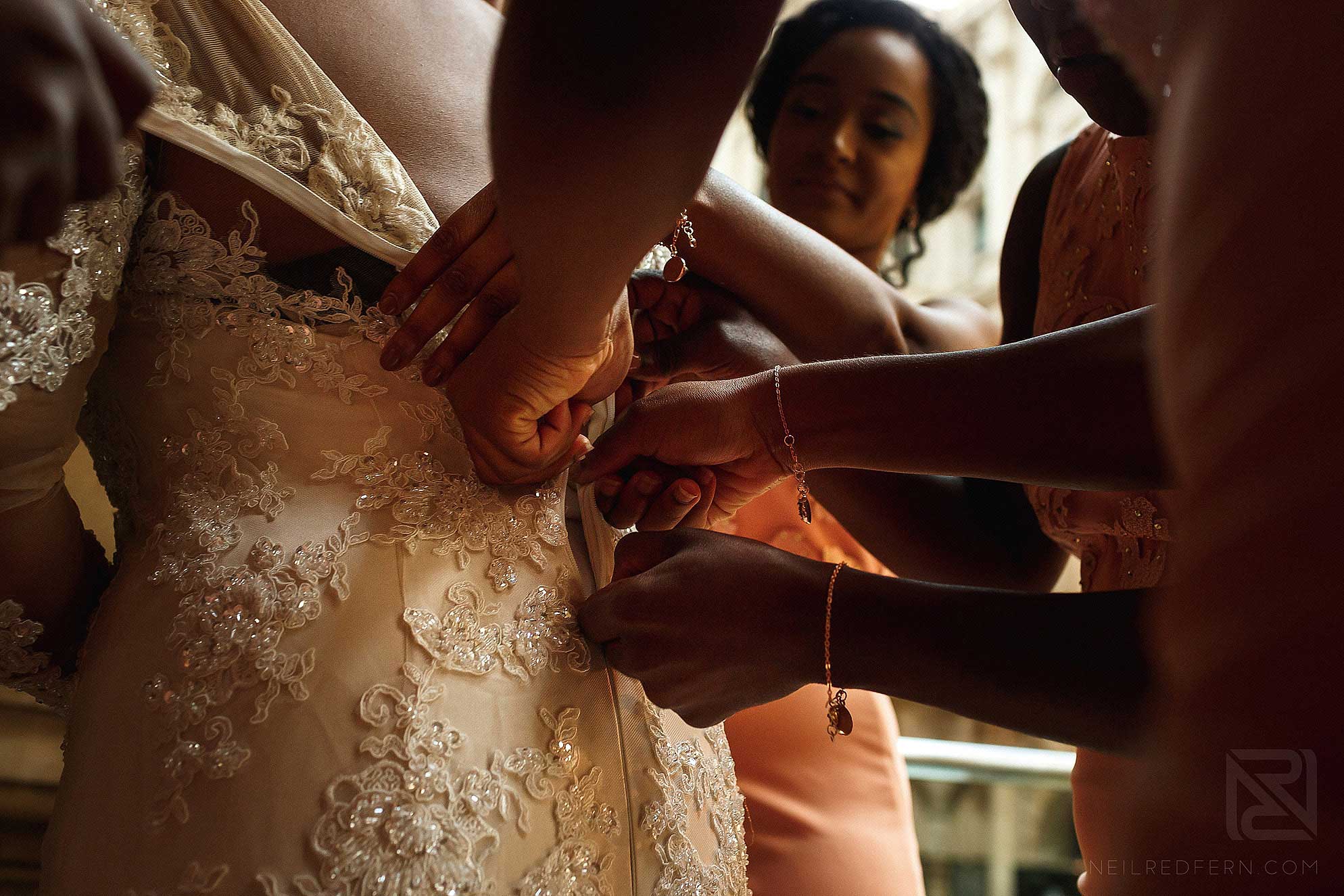 bride putting on wedding dress