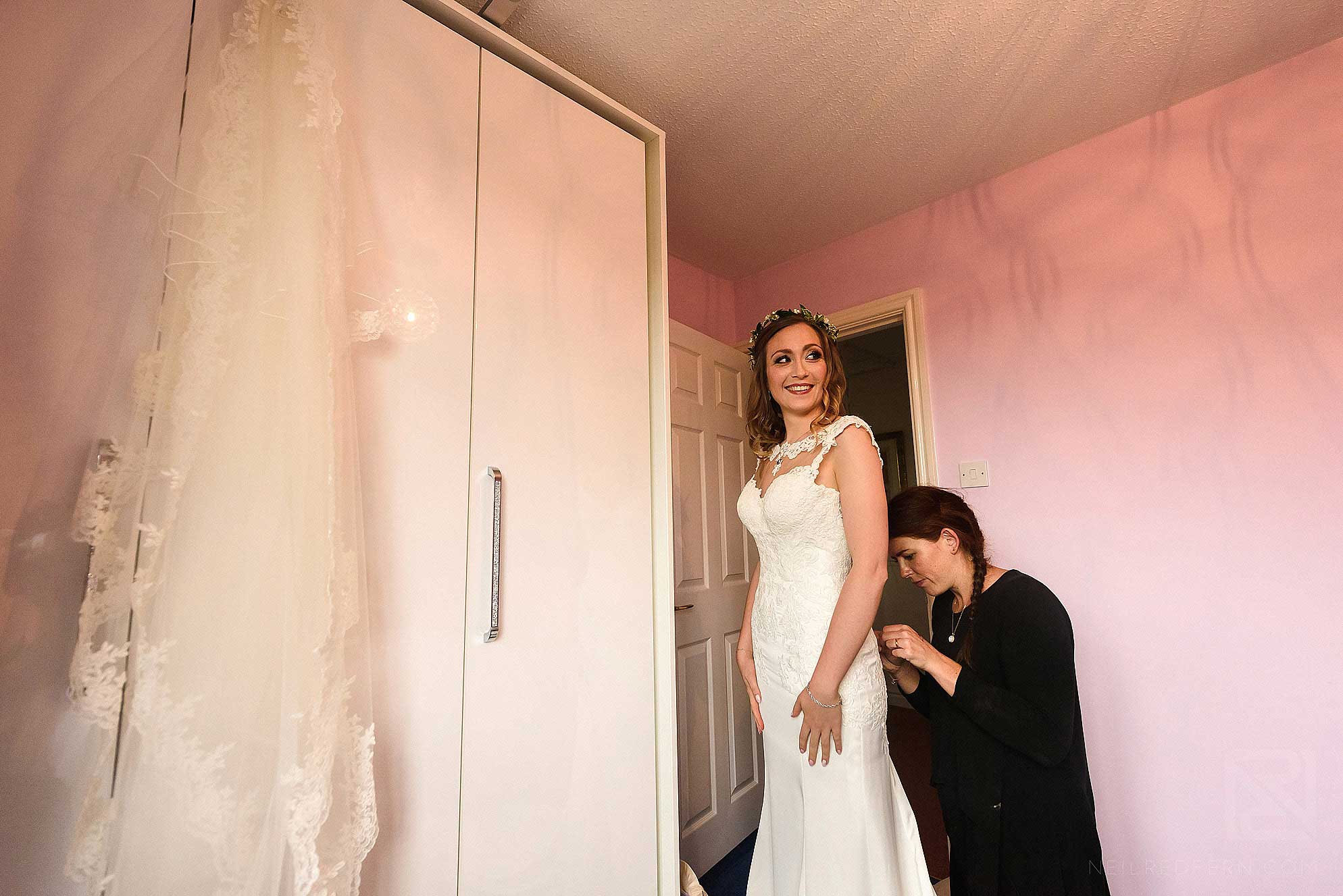 Abbeywood Estate wedding photography 6 bride putting on wedding dress