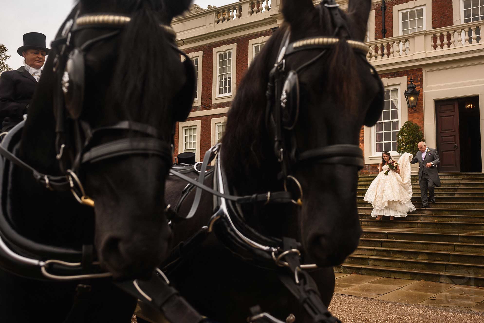 bride and gather going to church in horse drawn carriage