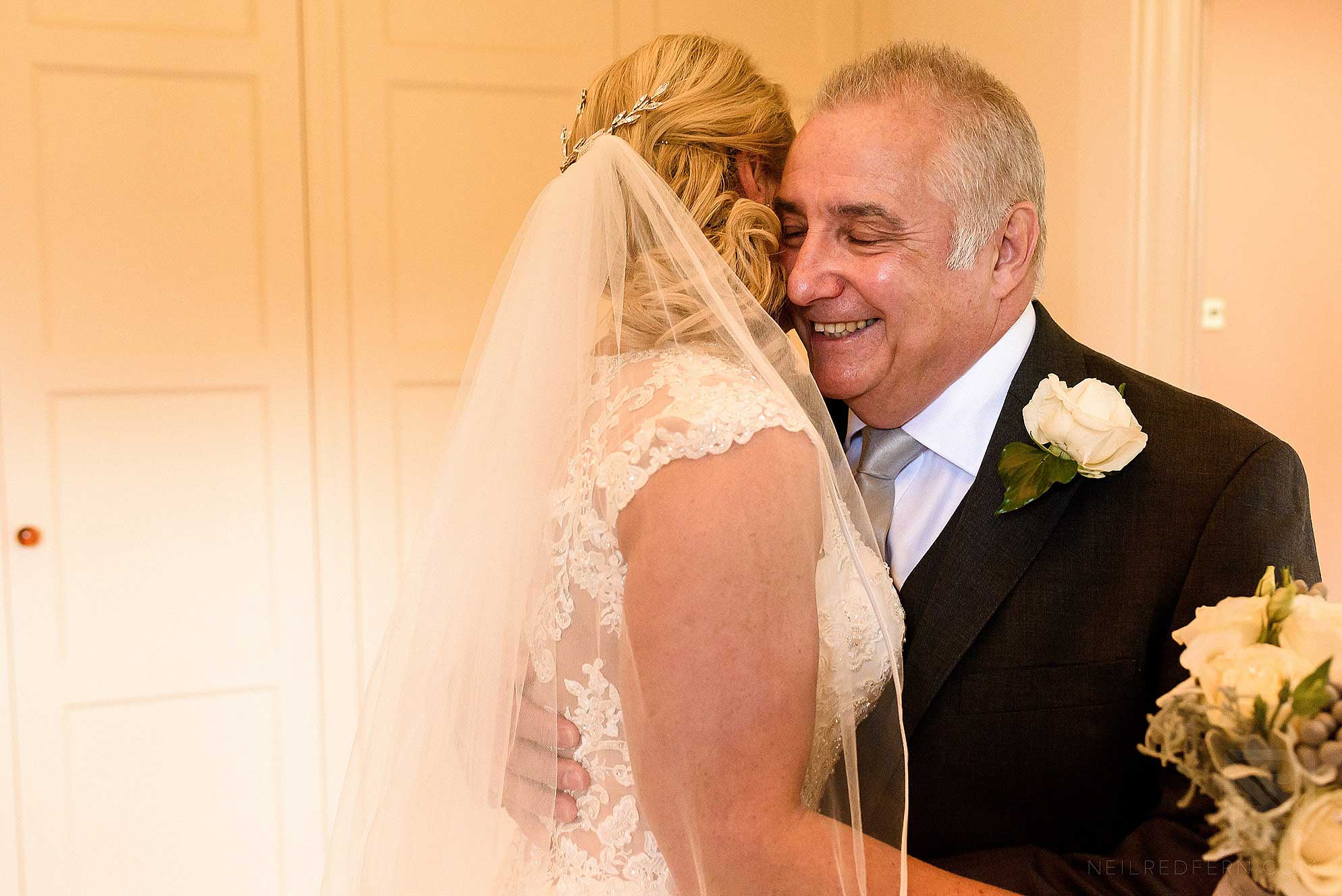 father hugging bride