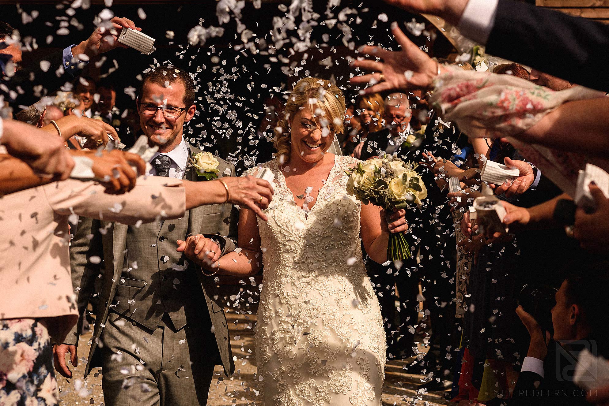 bride and groom walking through confetti