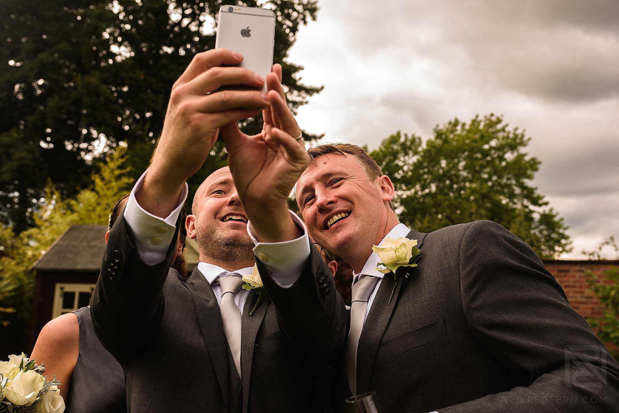 groomsmen taking photographs with phone