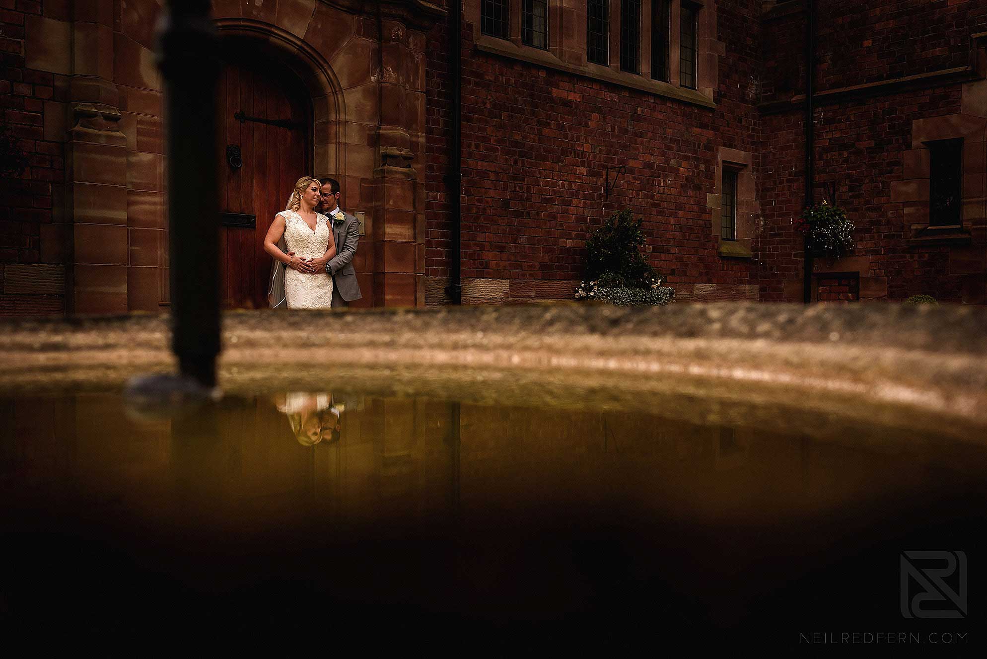 reflection of bride and groom in fountain