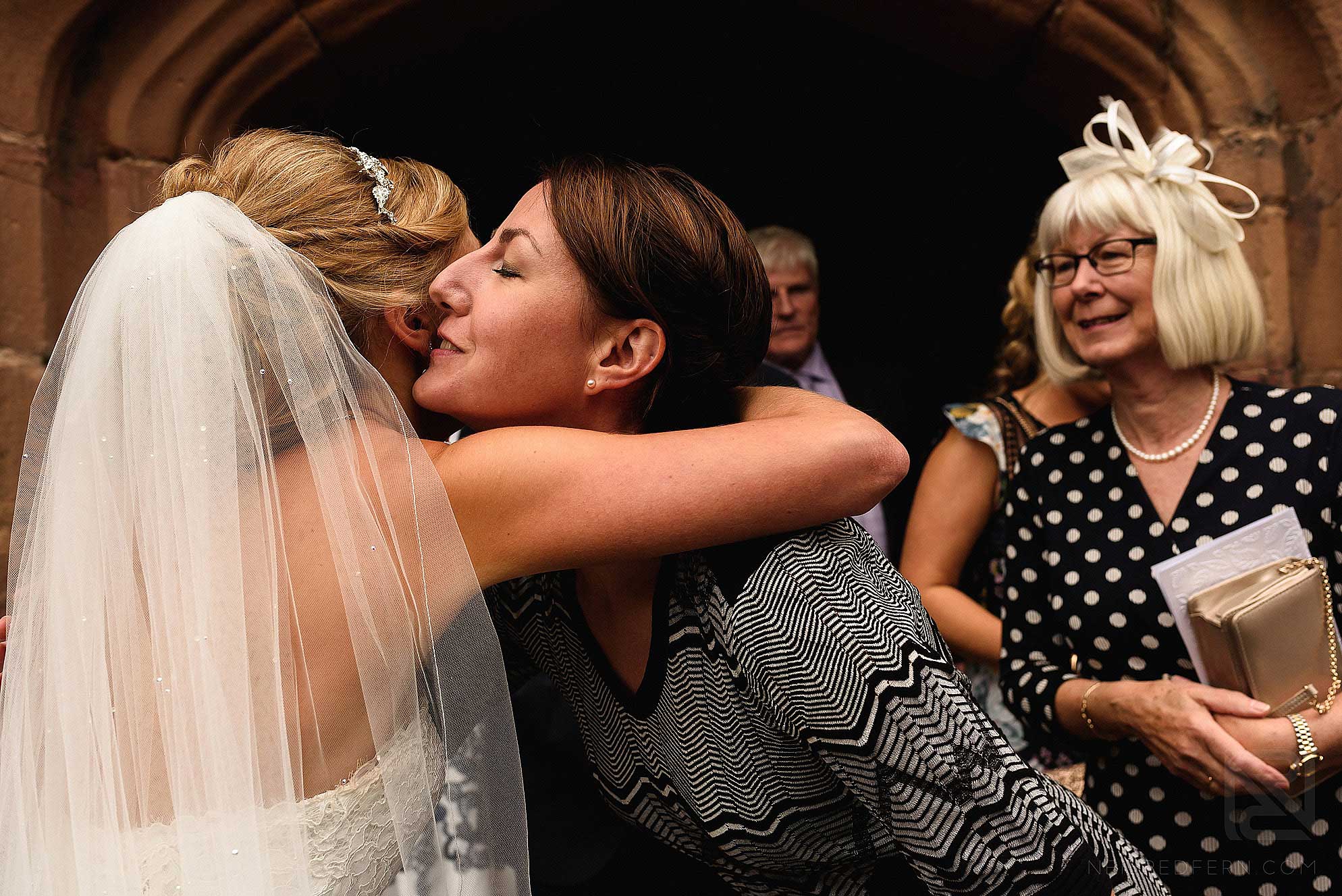 bride hugging friend outside church