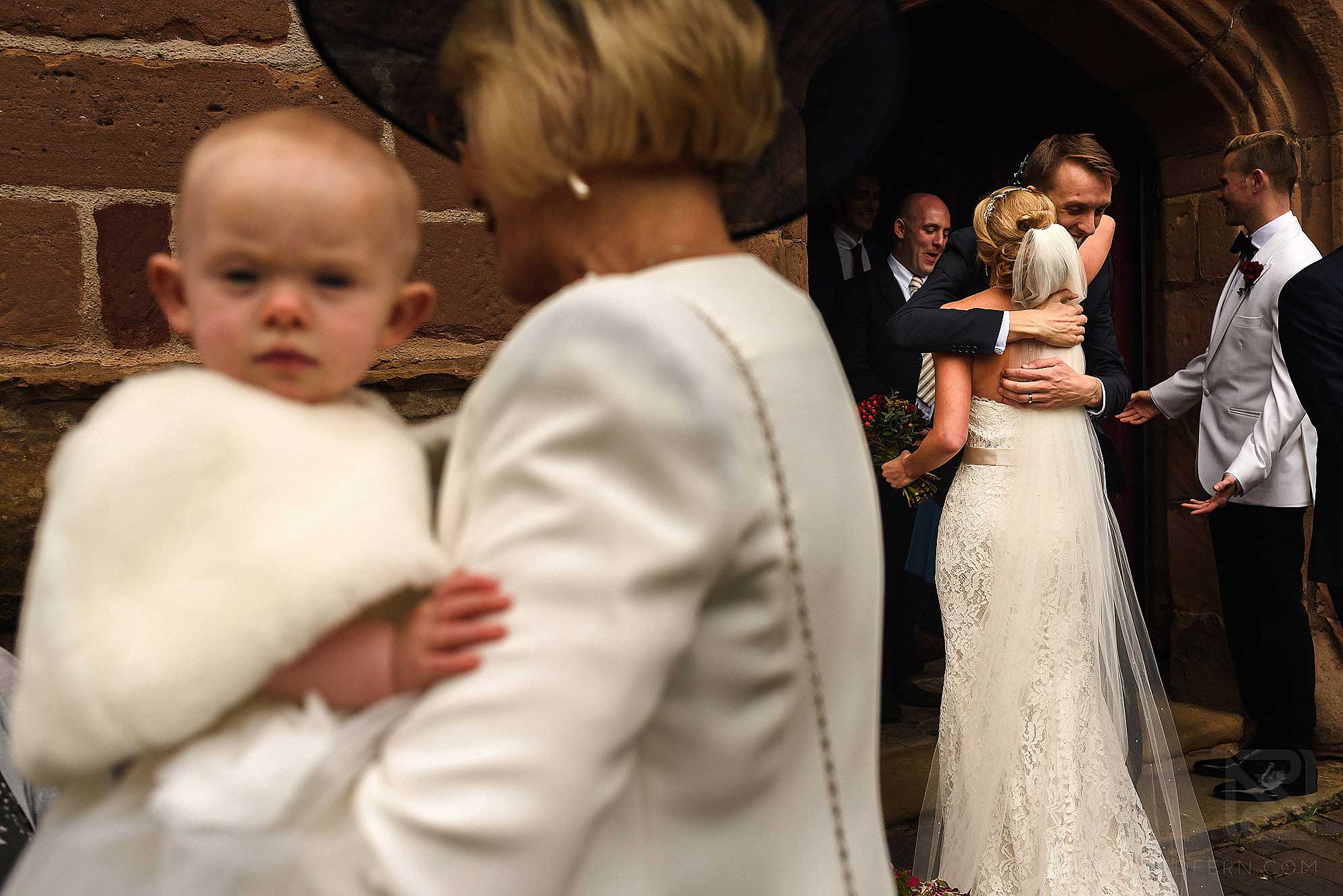 bride hugging guests as they leave church