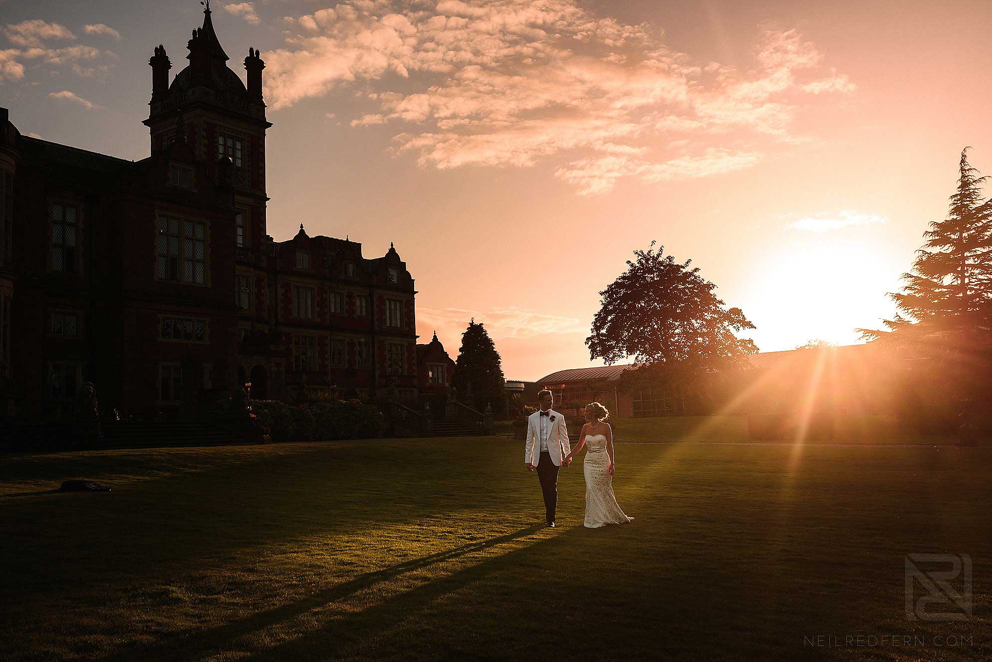 bride and groom walking through the gardens at Crewe Hall in Cheshire