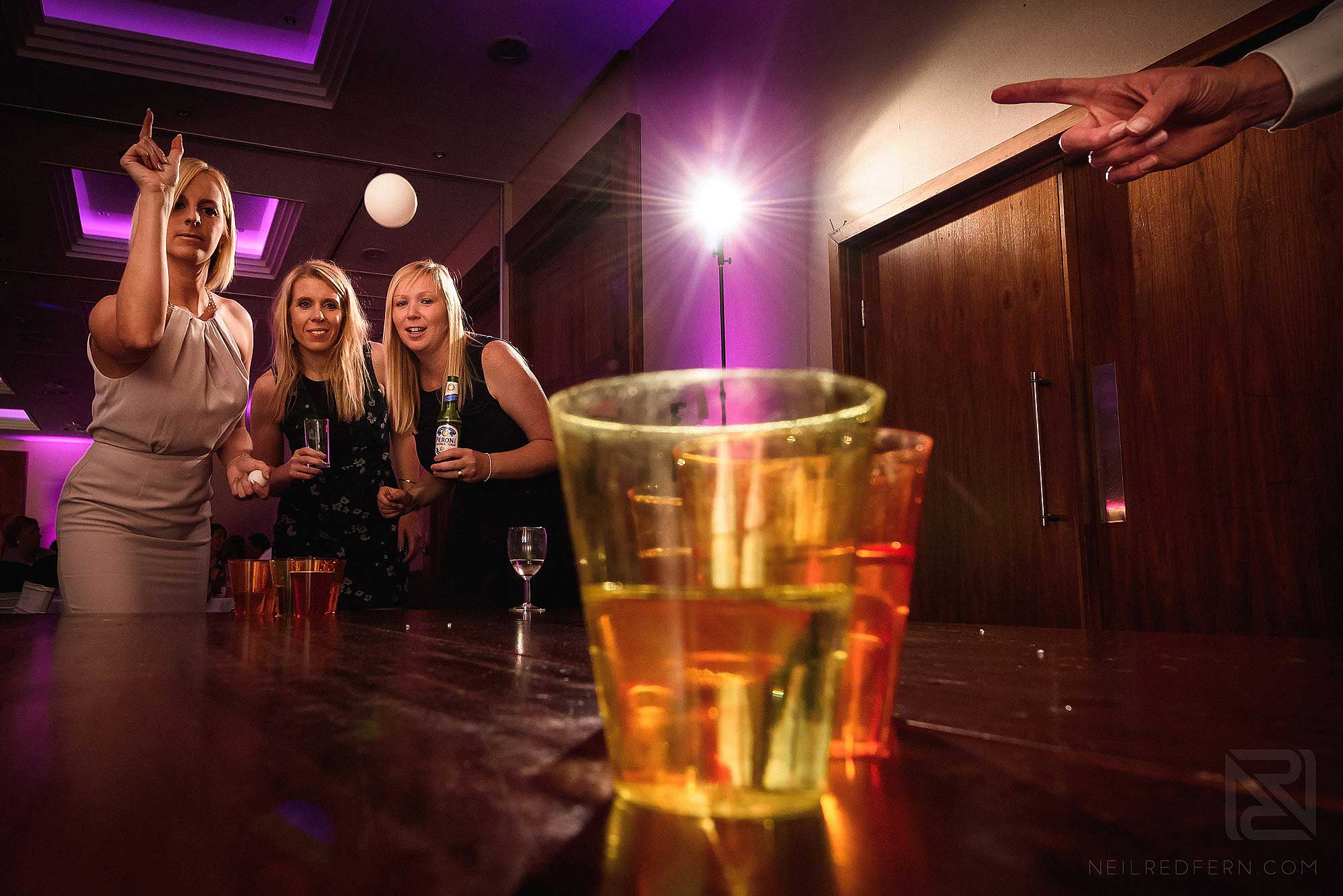 girls playing beer pong at wedding