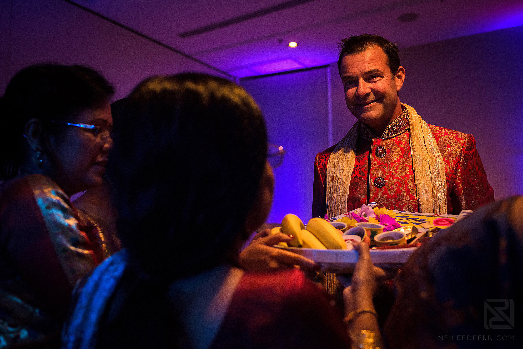 groom being offered food during wedding ceremony