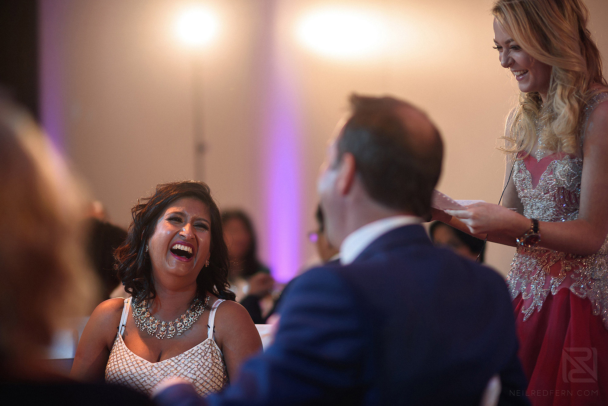 bride and groom laughing during wedding speeches