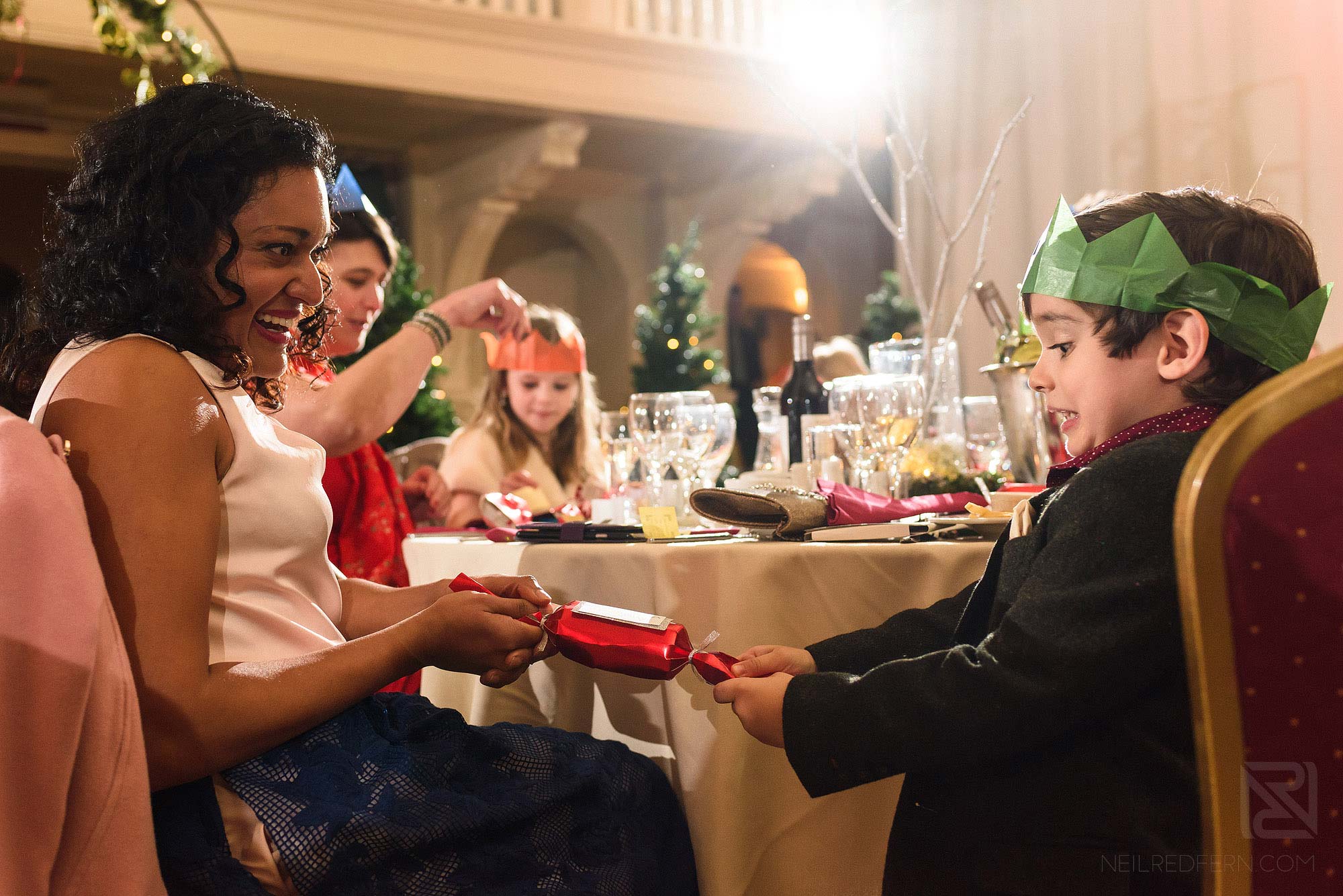 wedding guests pulling cracker at Christmas wedding at The Bowdon Rooms