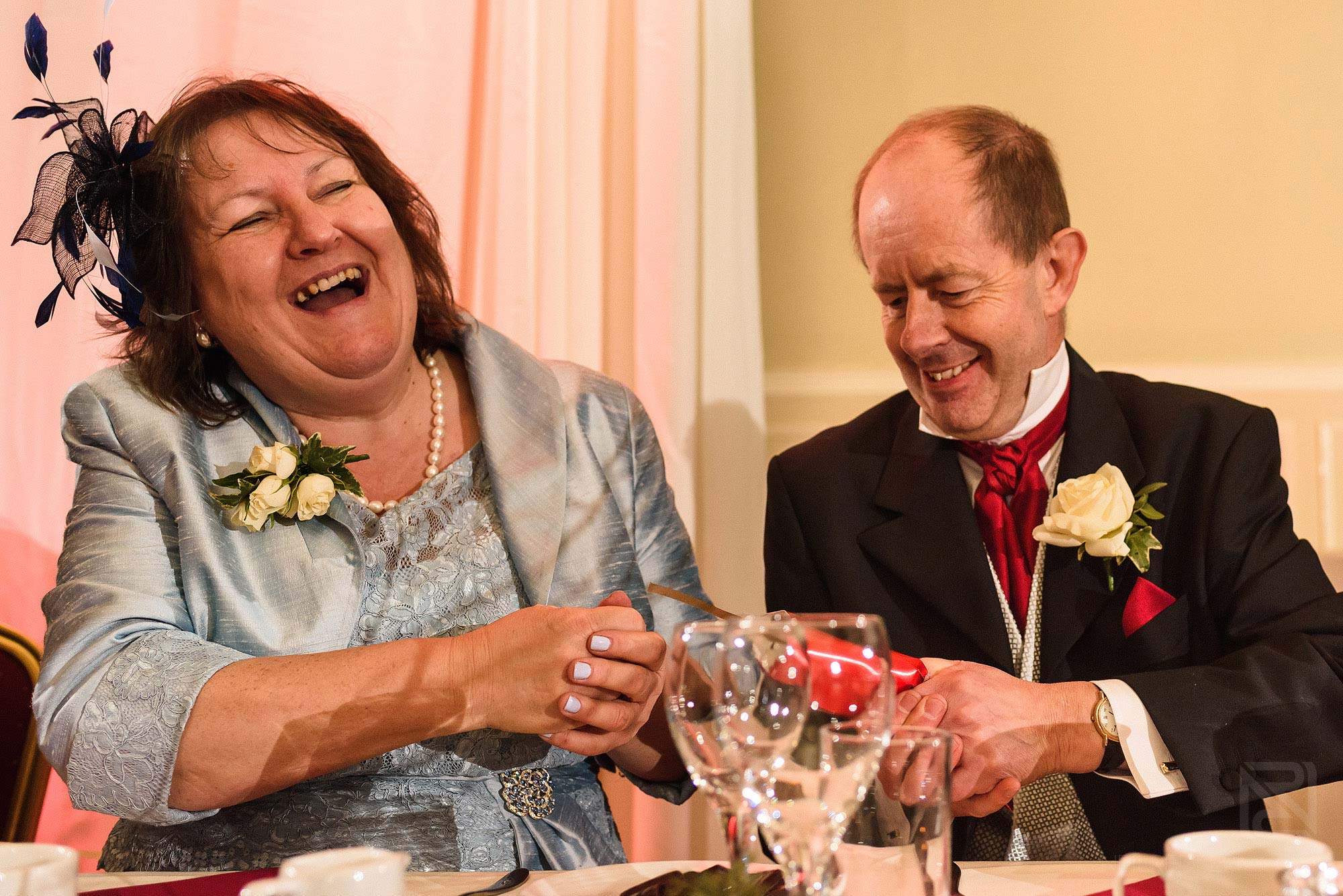 parents pulling a Christmas cracker at wedding