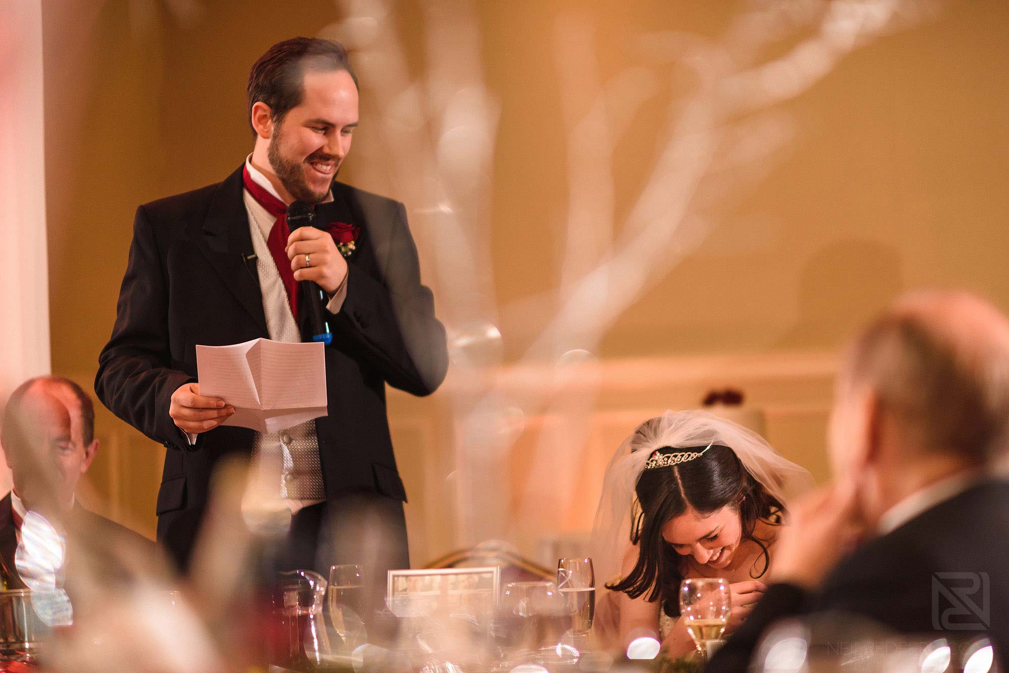 bride laughing during groom's wedding speech
