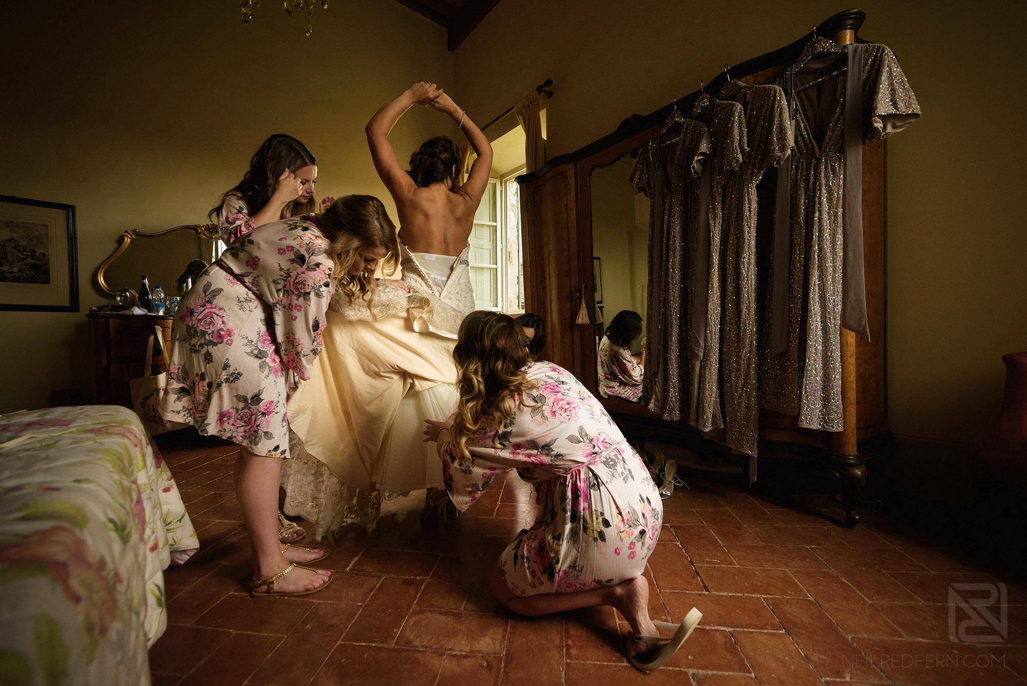 bride putting on wedding dress in Tuscany