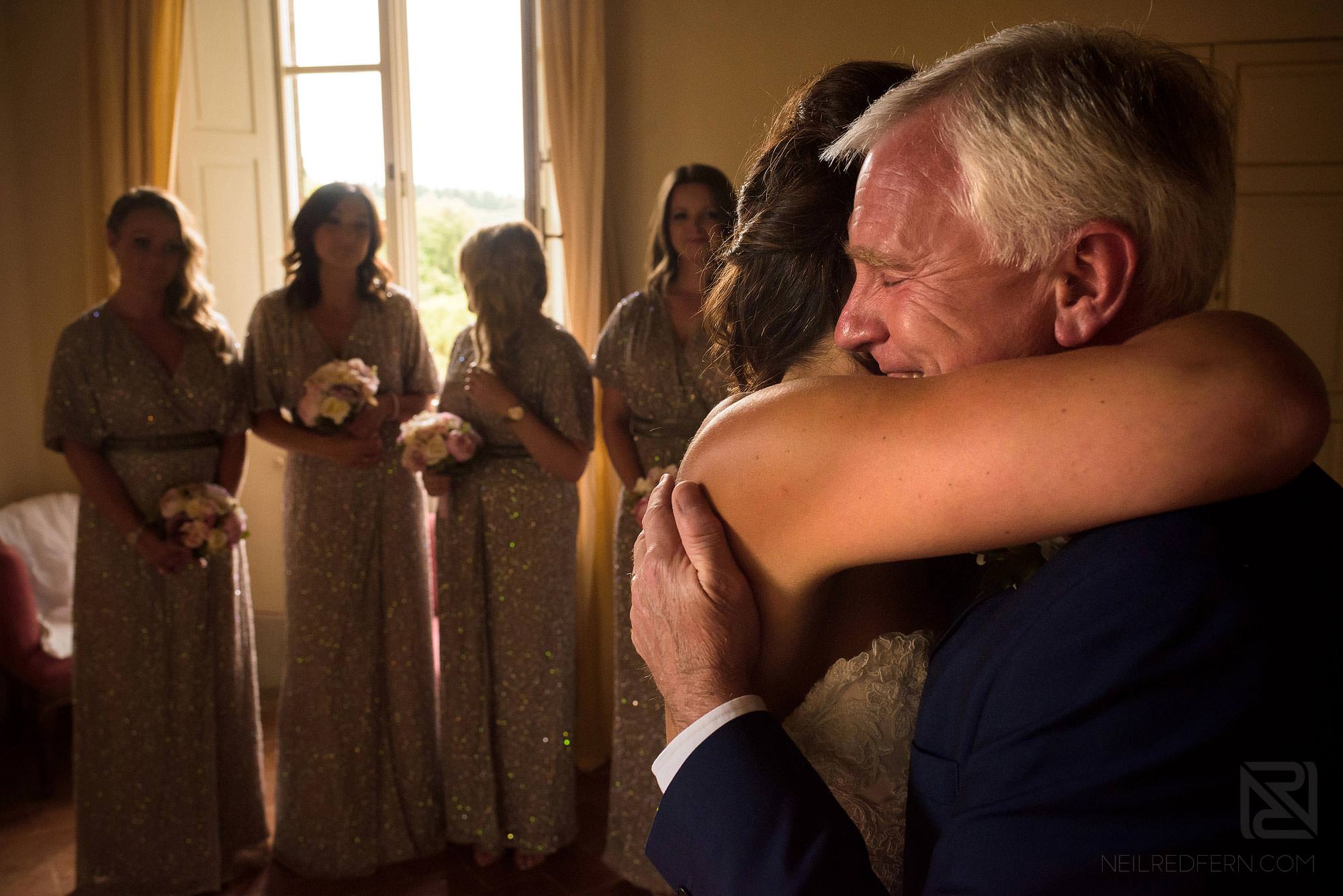 father of bride hugging bride