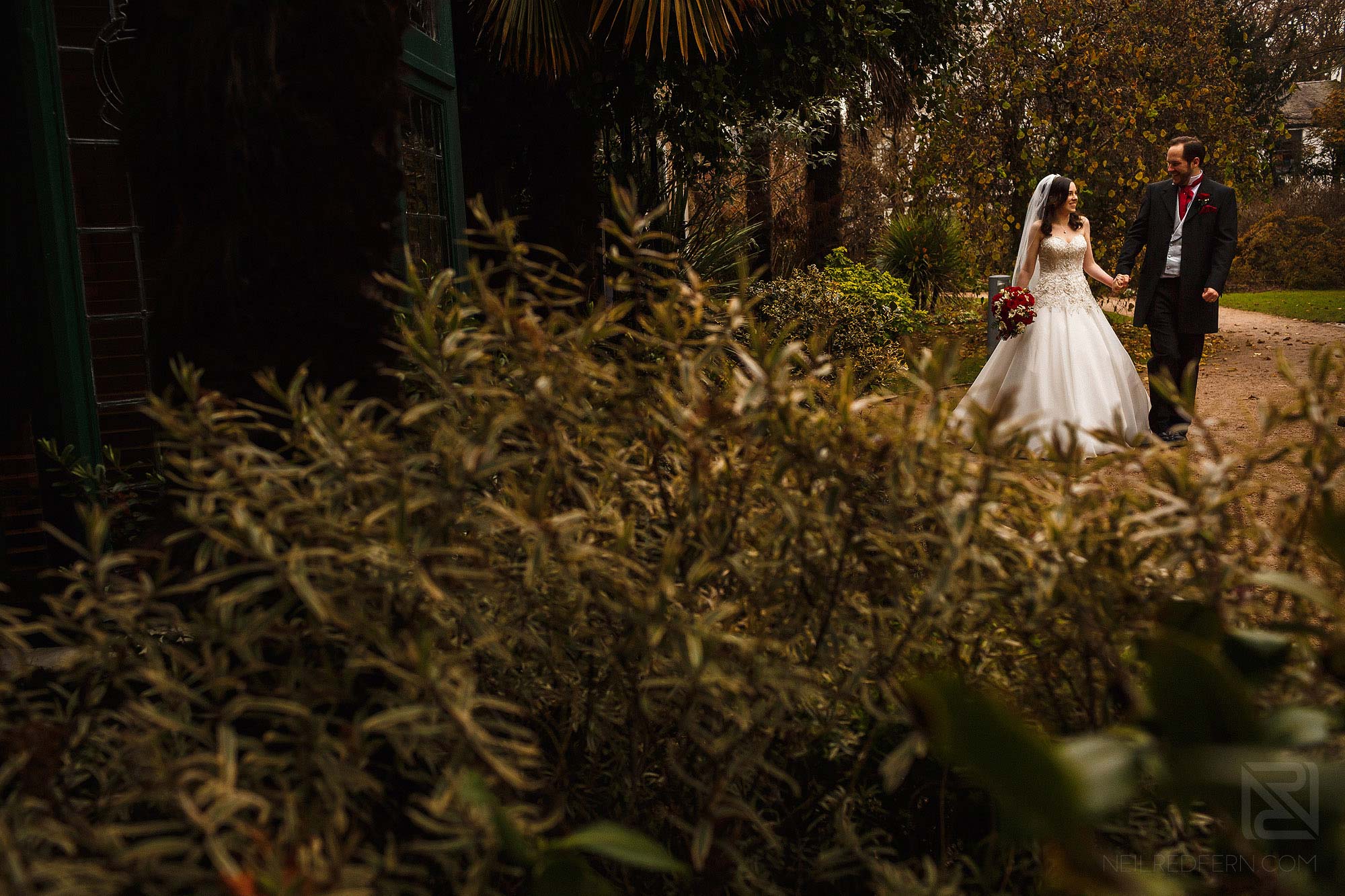 bride and groom walking through park in Manchester