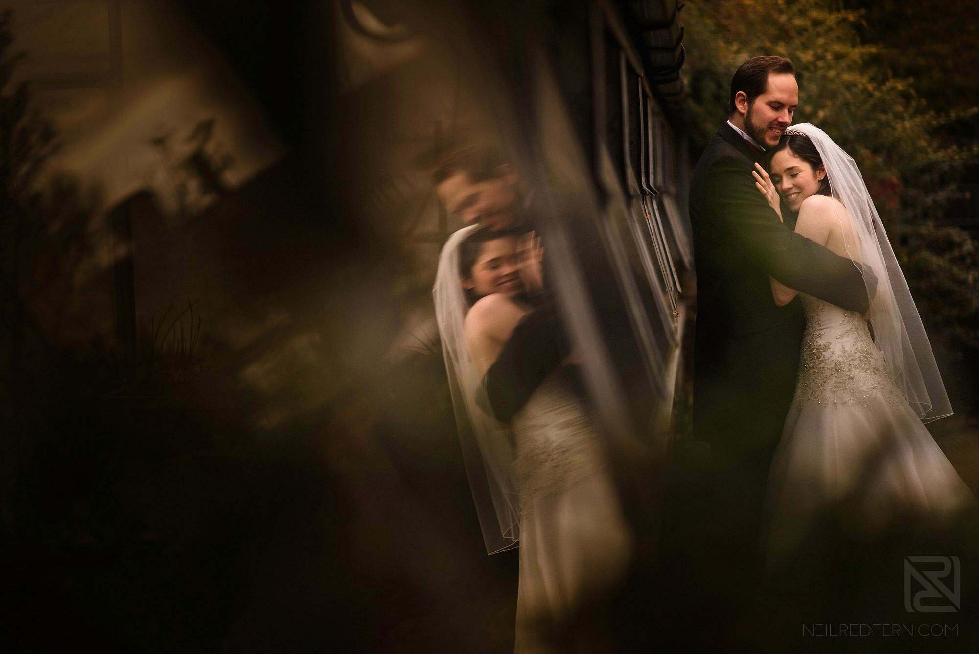 romantic photograph of bride and groom with reflection in glass