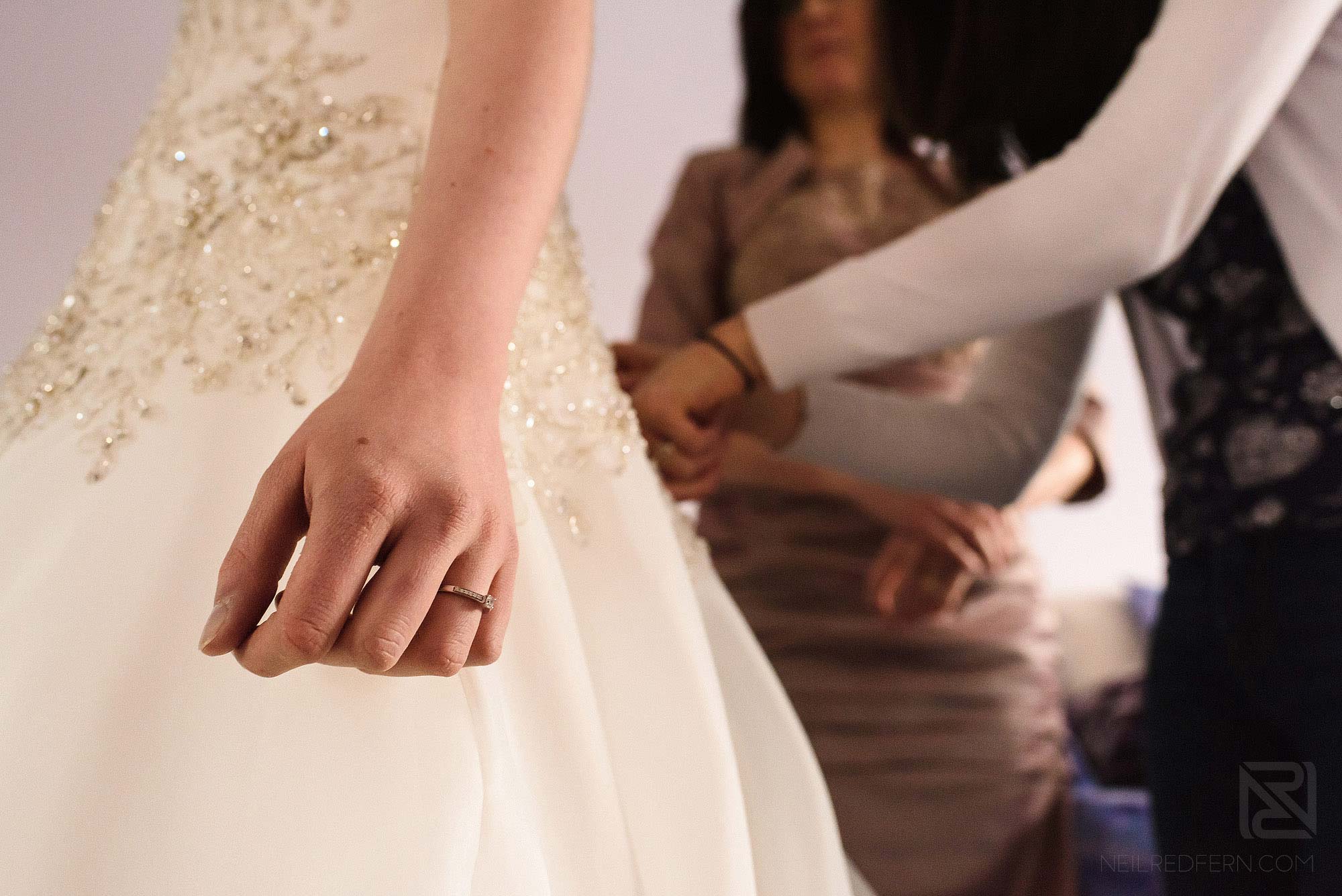 bride putting on wedding dress
