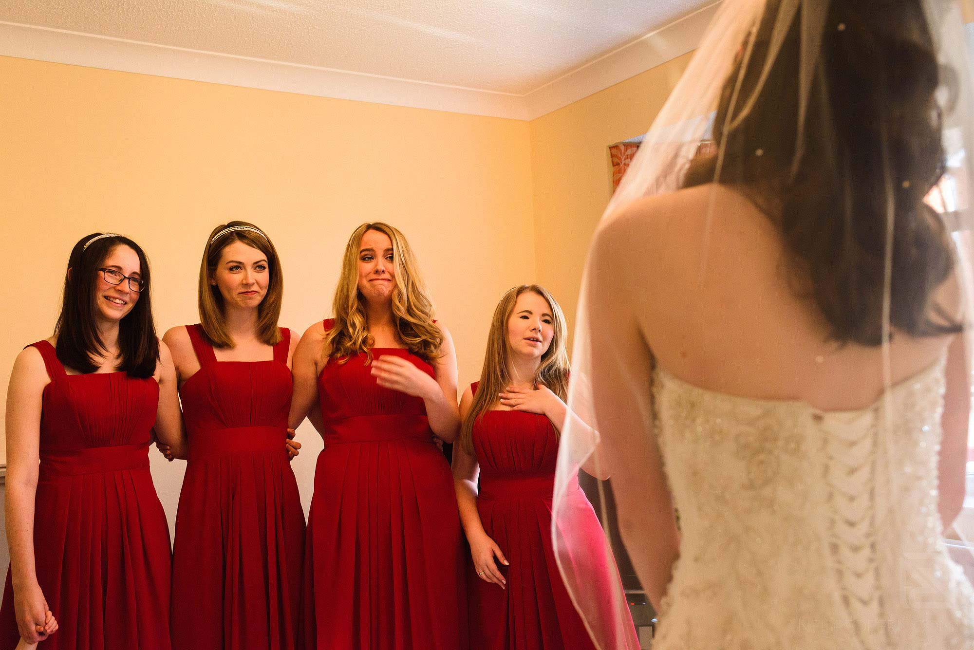 bridesmaids seeing bride in wedding dress for the first time