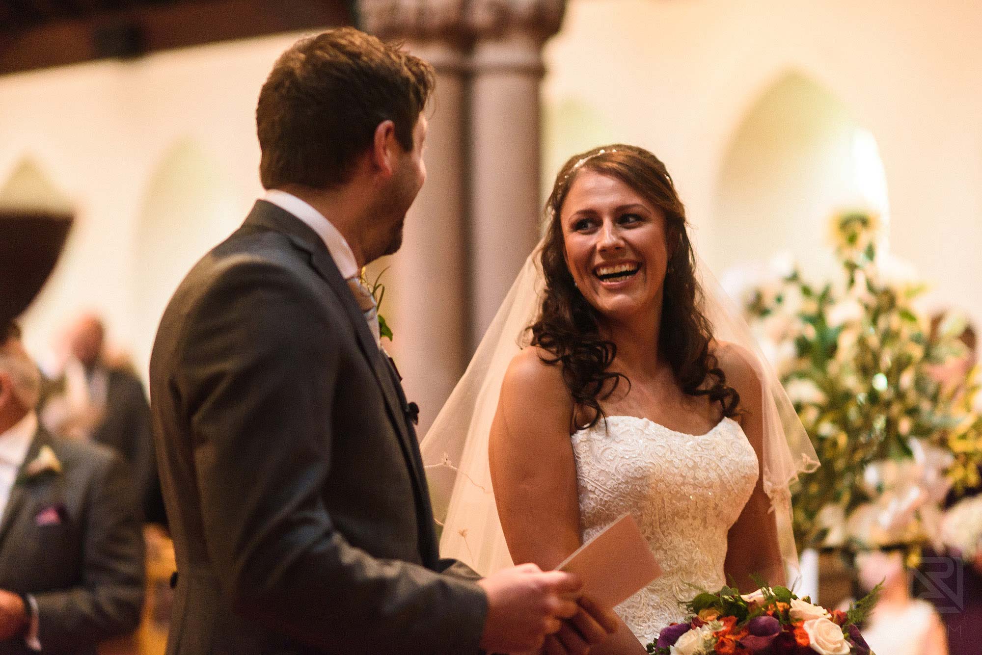 bride and groom laughing during wedding ceremony