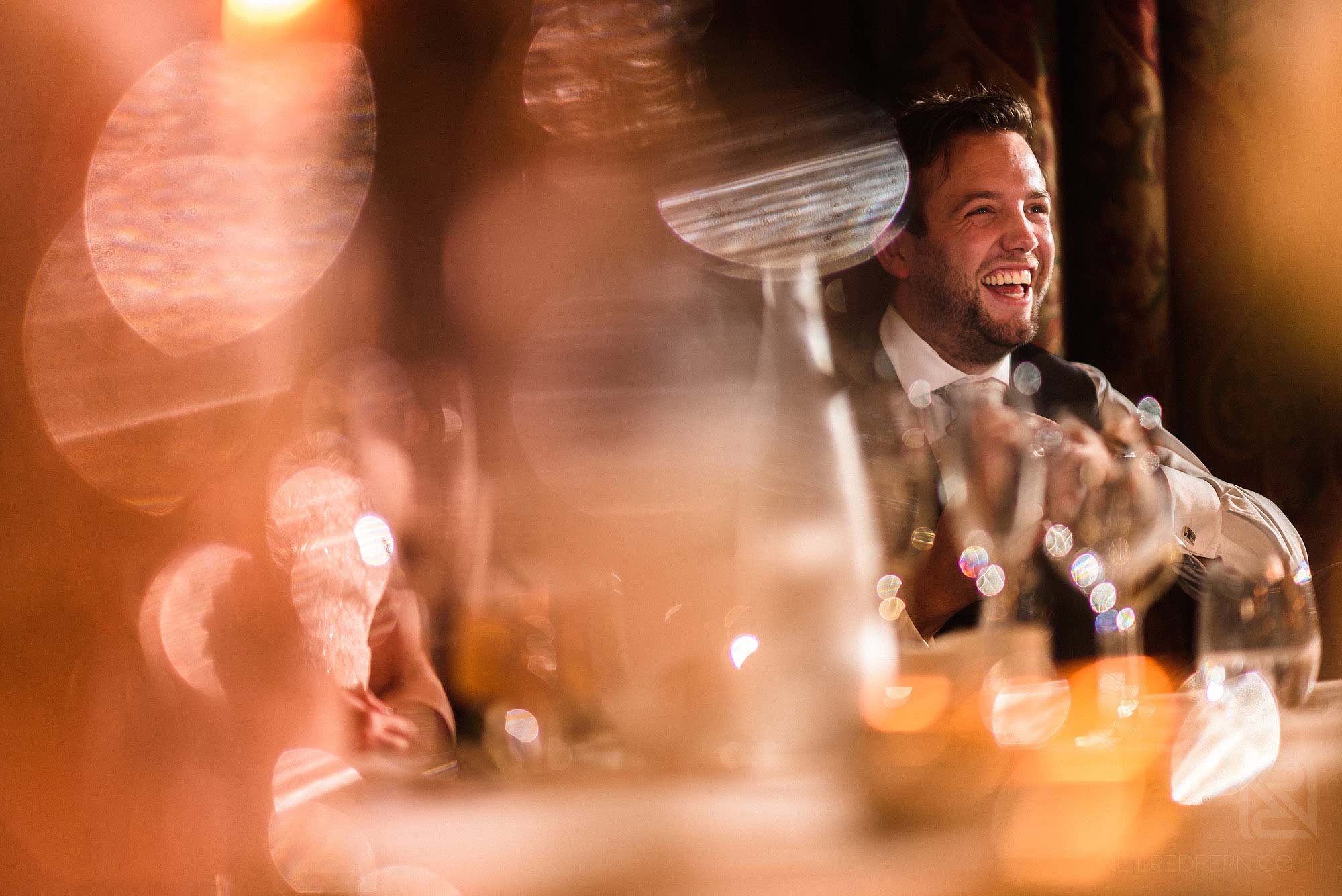 groom laughing during wedding speeches