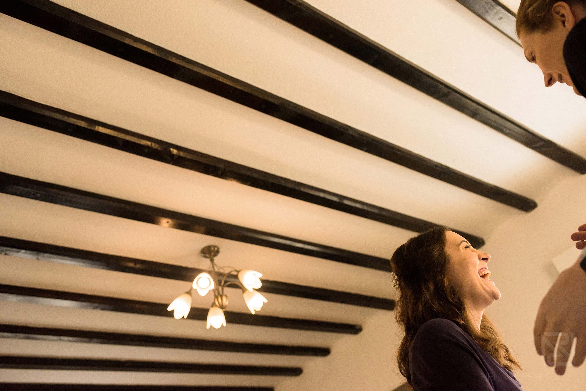 bridesmaid laughing whilst getting ready ready for wedding