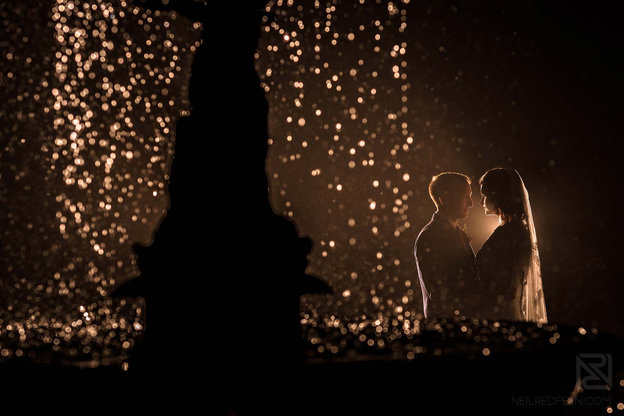 creative photograph using flash of bride and groom next to a fountain in the Lake District