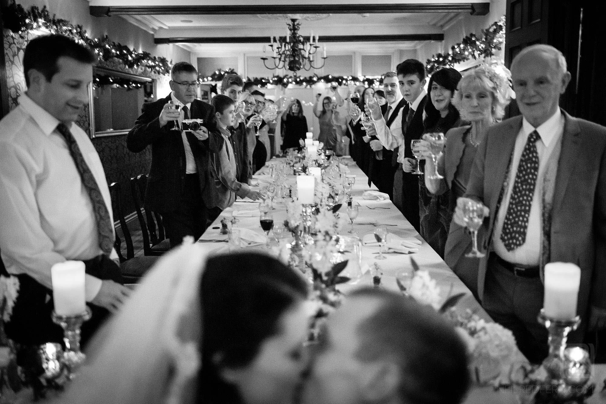 guests looking at bride and groom kissing during wedding breakfast
