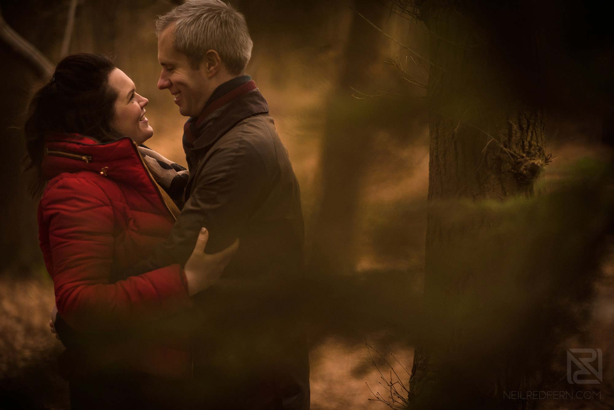 Woodland engagement shoot 5 engaged couple smiling at each other on woodland engagement shoot
