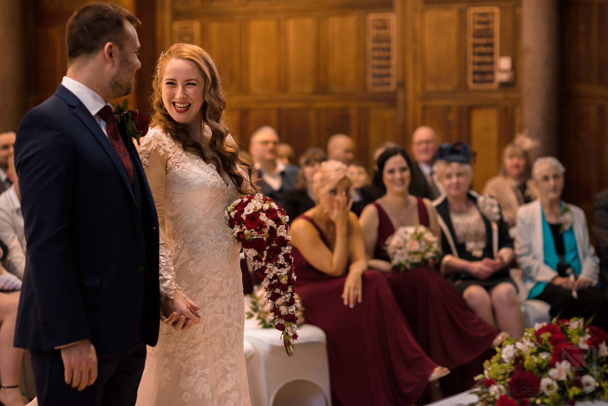Manchester Museum wedding photography 16 bride and groom smiling during wedding ceremony at Whitworth Hall