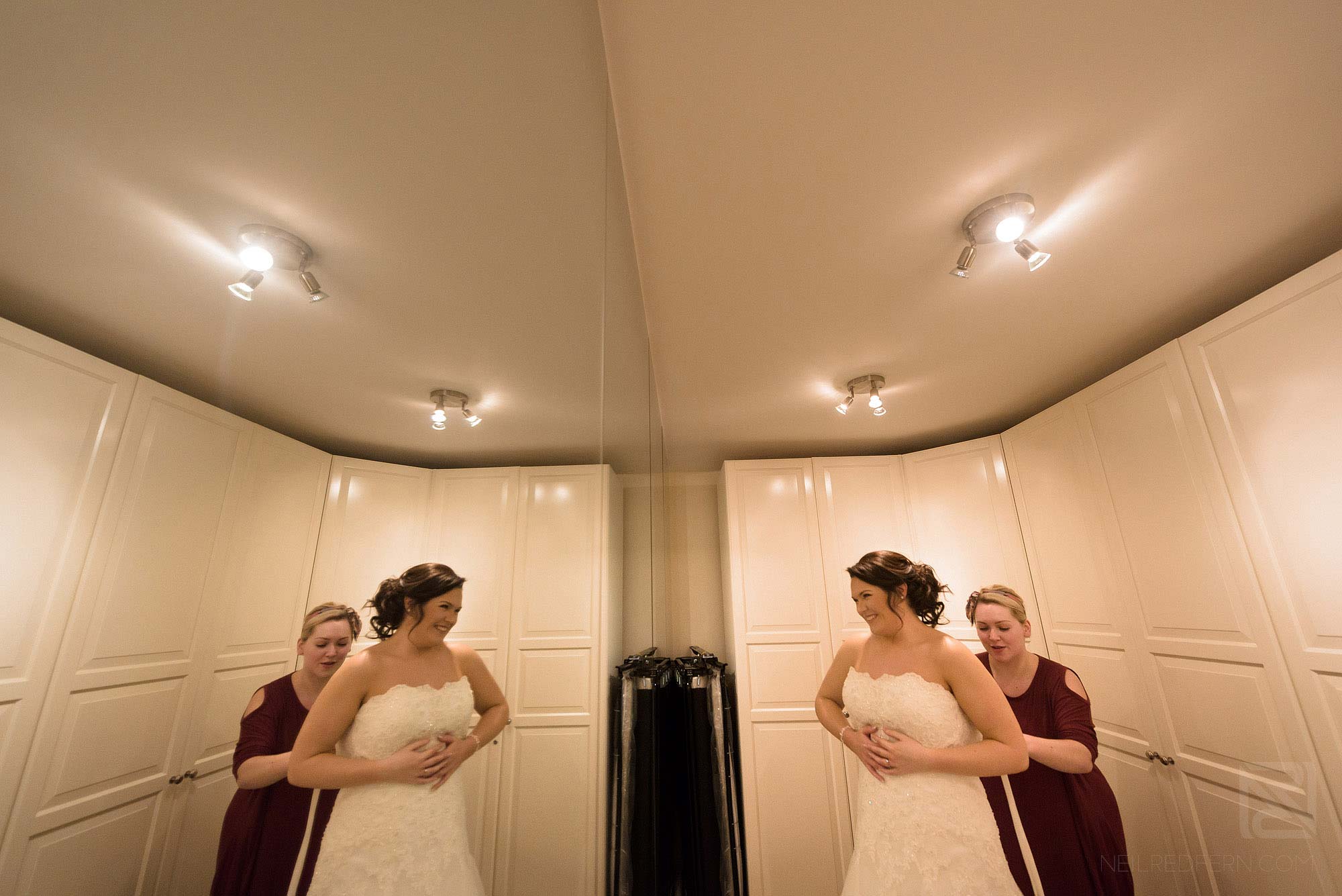 bride putting on wedding dress before ceremony