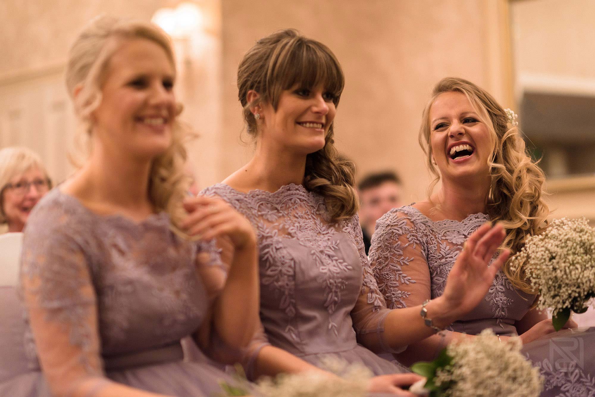 bridesmaids laughing during wedding ceremony