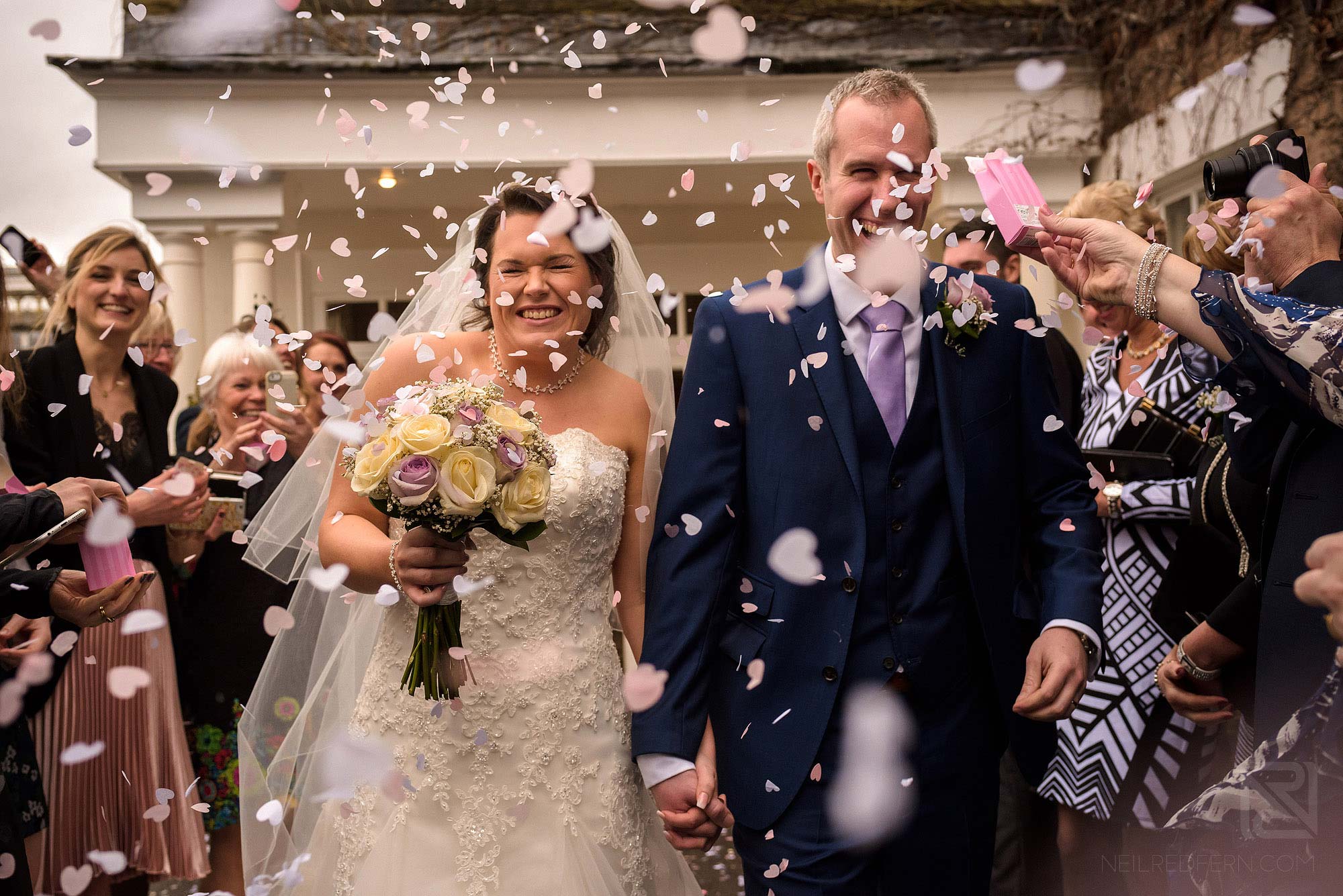 lots of confetti being thrown at bride and groom