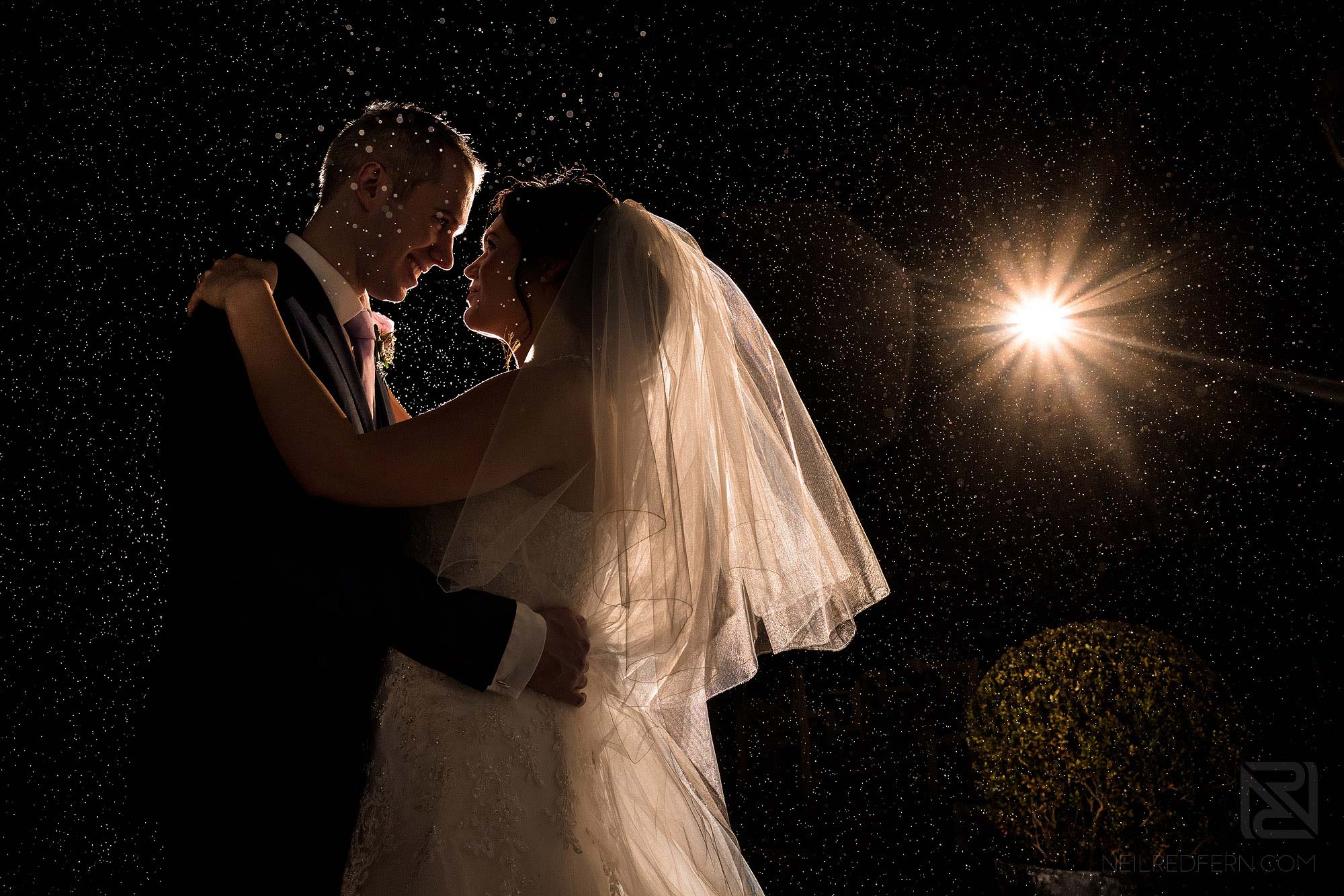 photograph of bride and groom in the rain at Rowton Hall