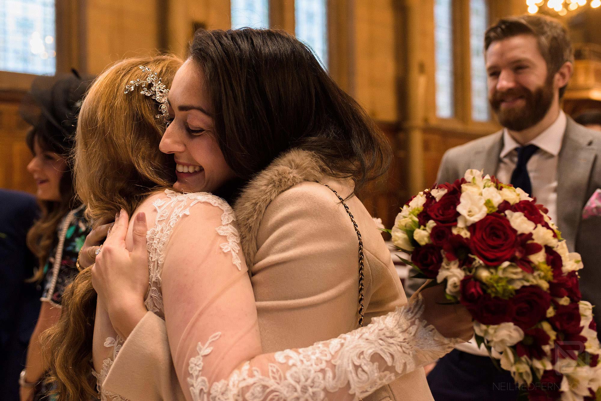 Manchester Museum wedding photography 20 friend hugging bride after ceremony
