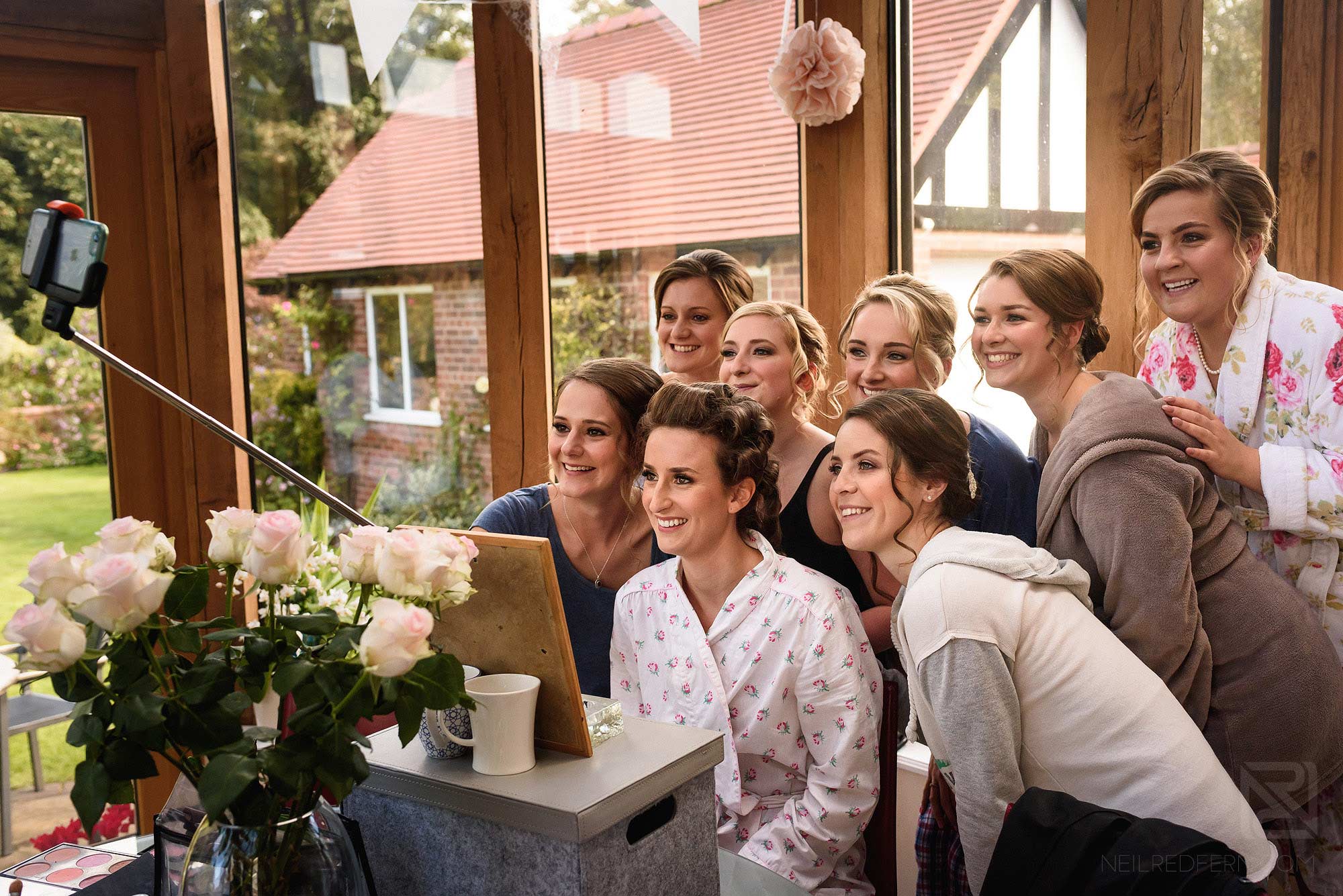 bride and bridesmaid taking selfie on morning of wedding