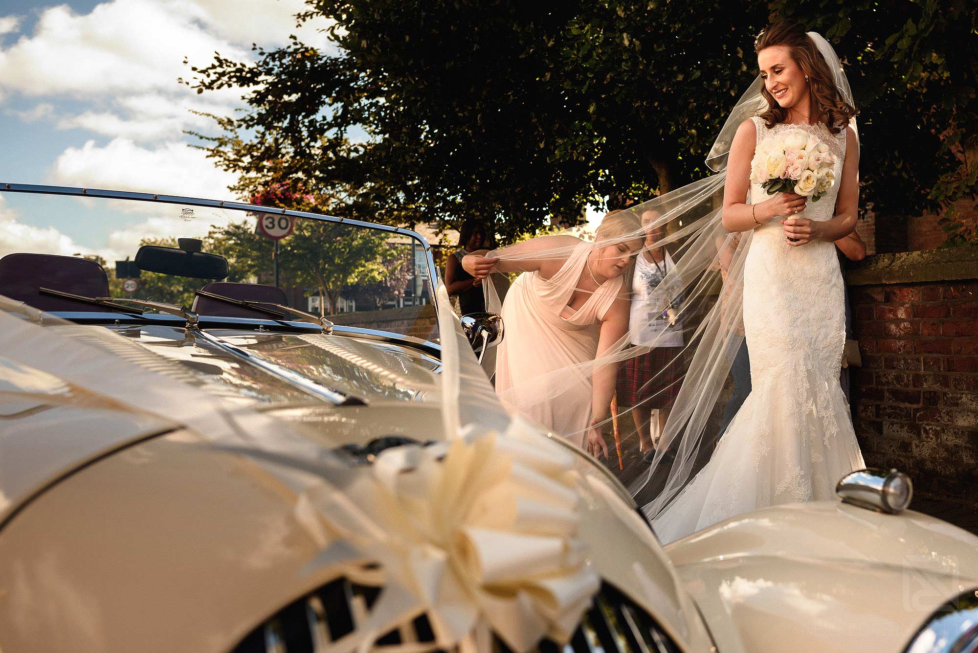 bride getting out of wedding car outside church