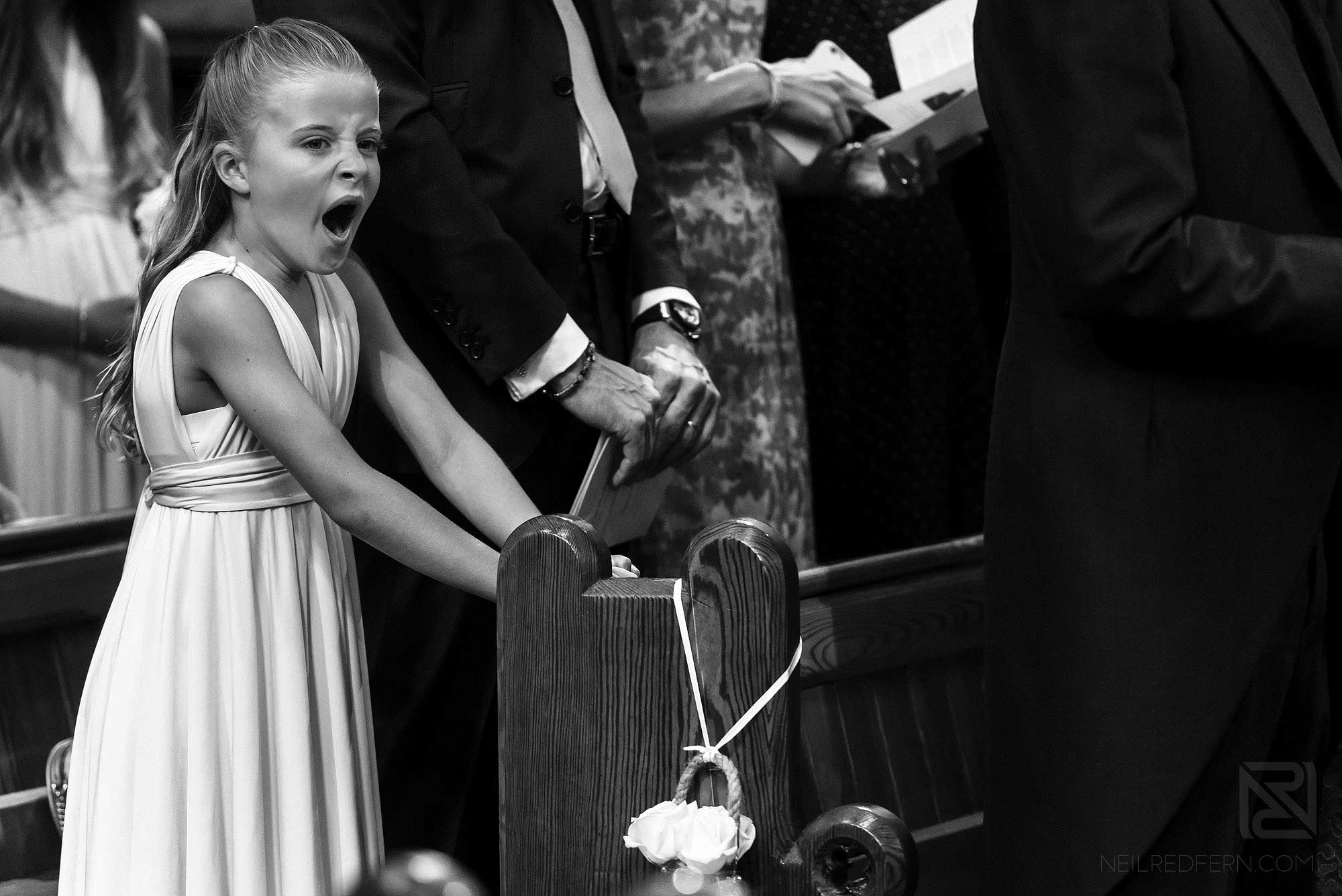 flower girl yawning during wedding ceremony