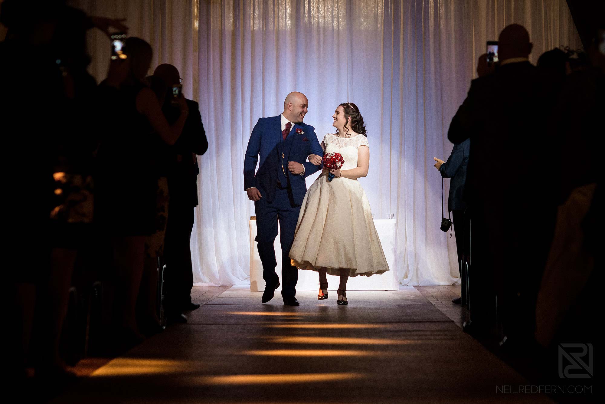 bride and groom walking back up the aisle at Rivington Hall Barn