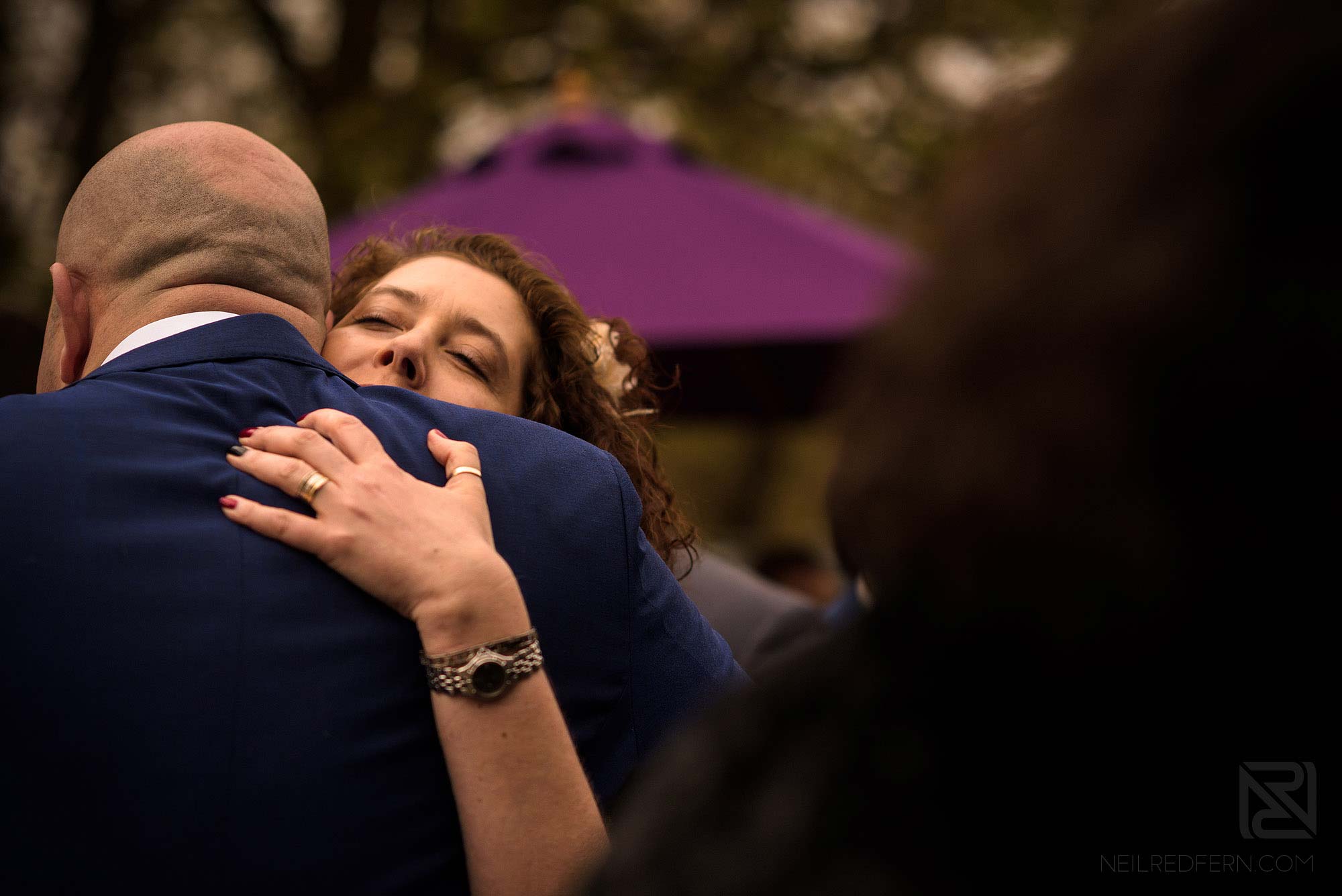 guest hugging groom outside Rivington Hall Barn