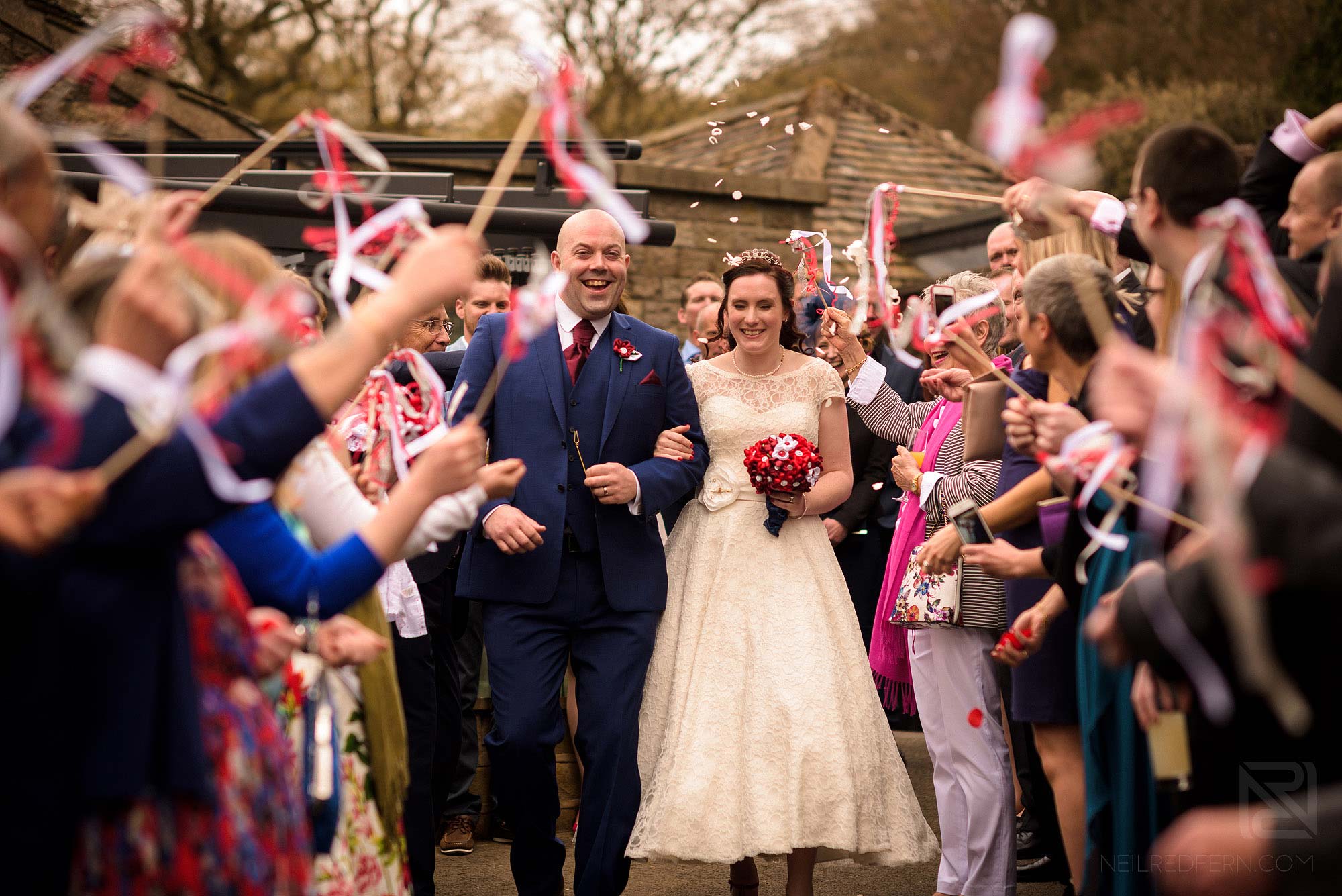 bride and groom with confetti and flags