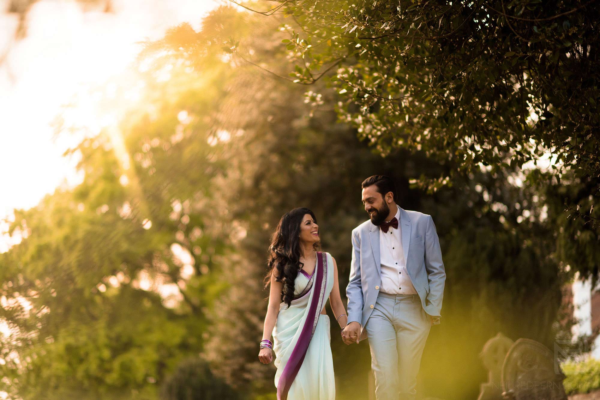 couple walking through gardens on summer evening