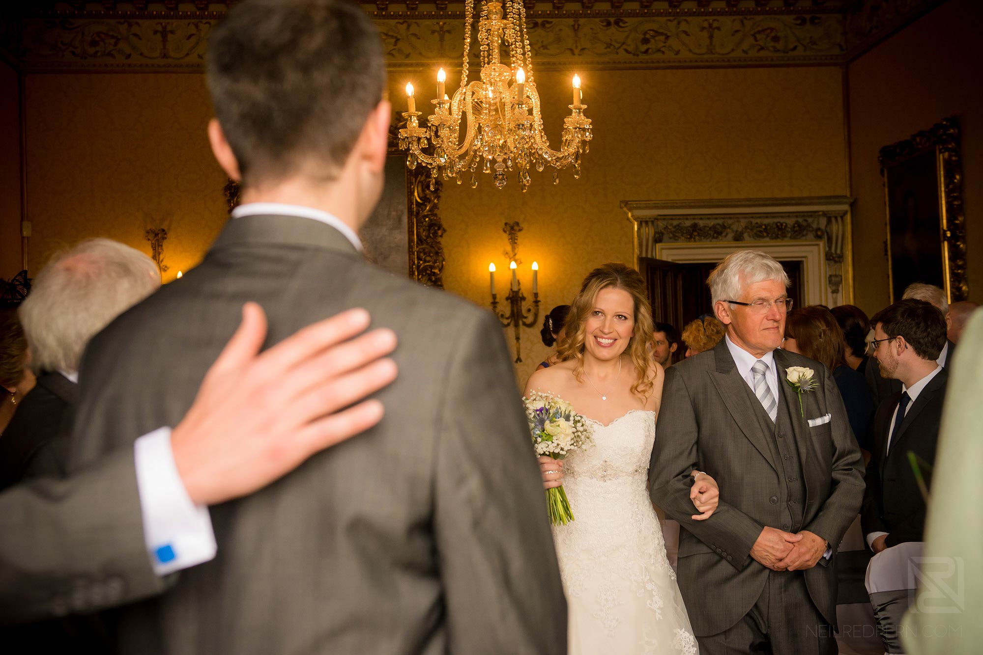 bride walking down aisle looking at groom