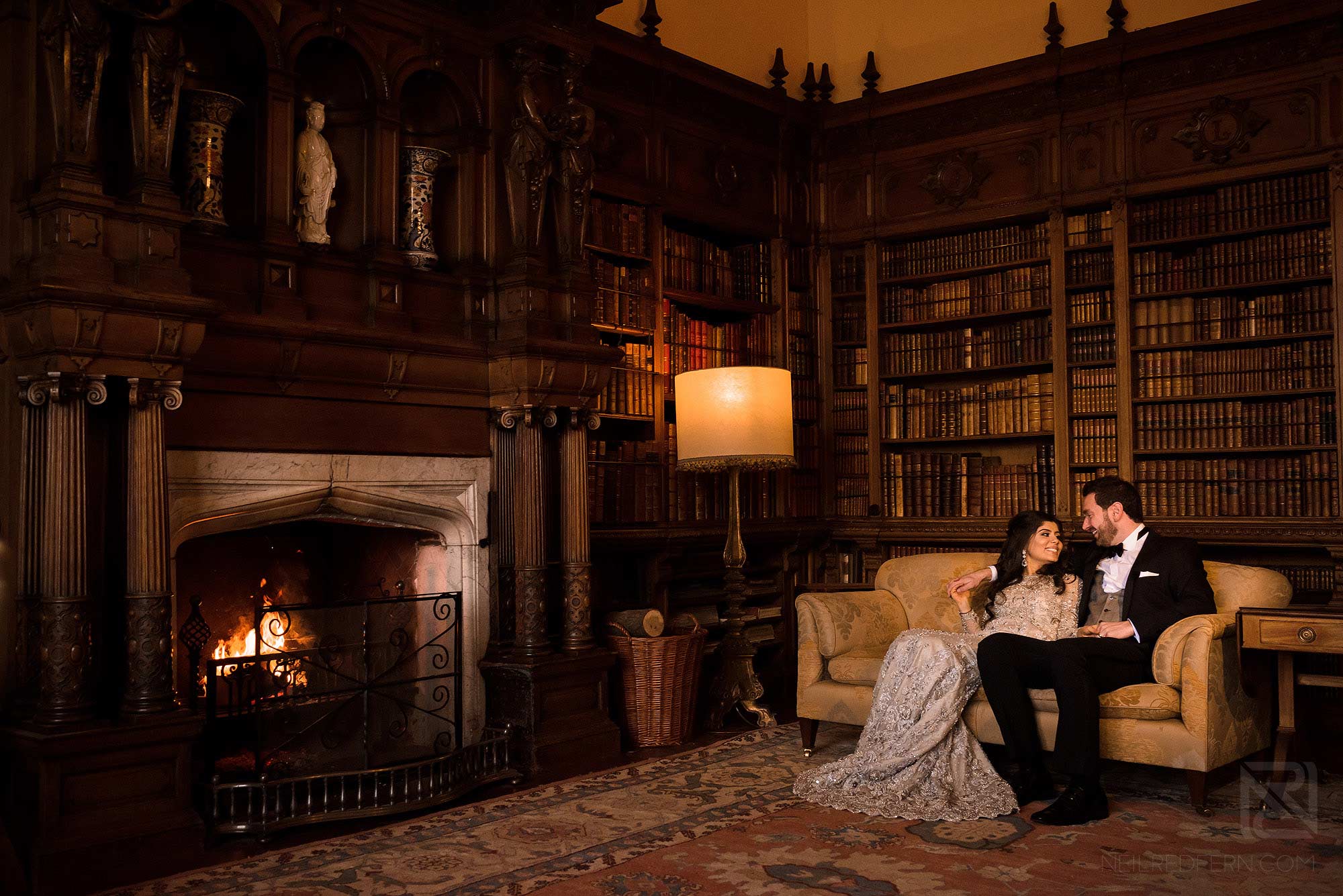 bride and couple sitting on chair in Arley Hall library