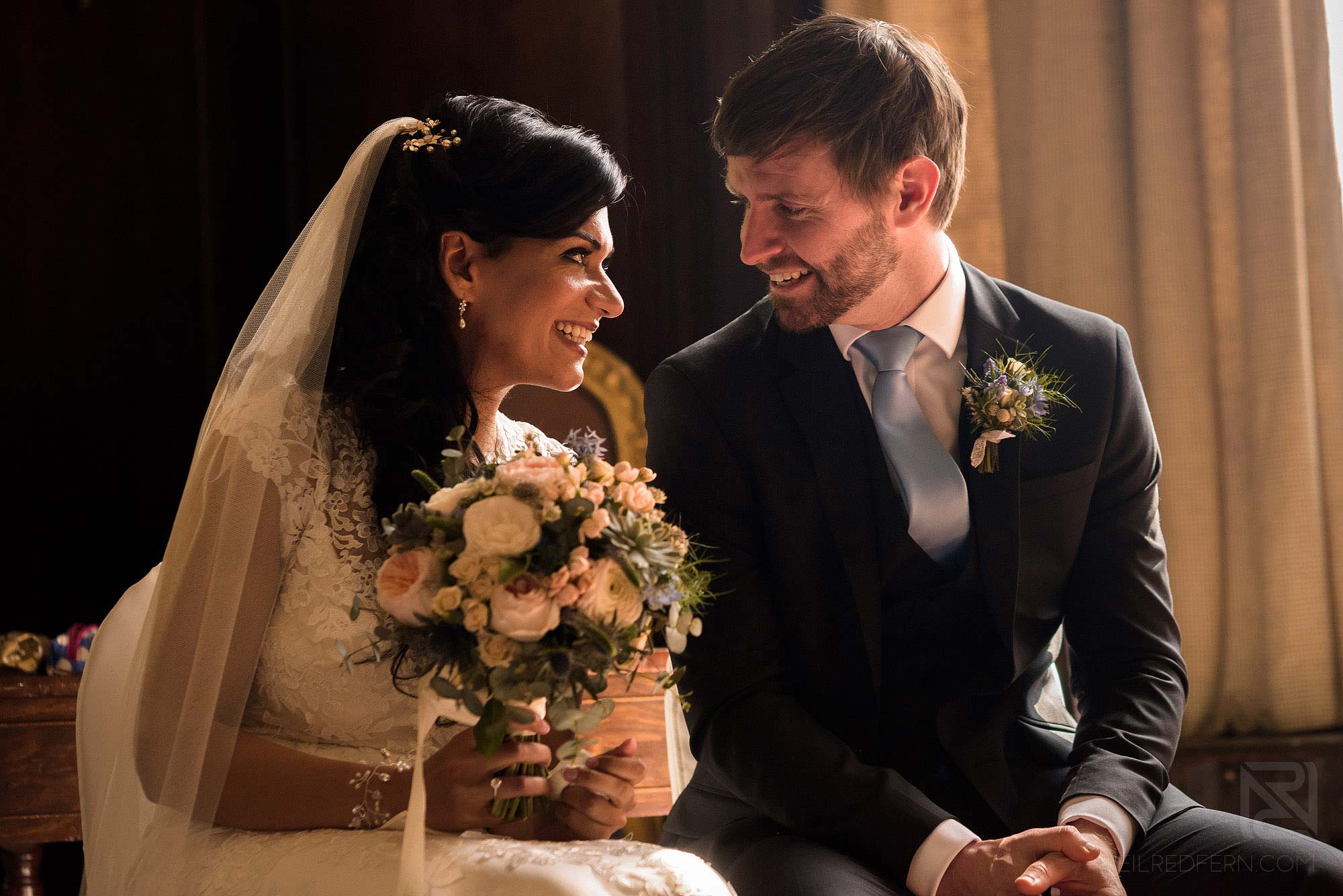 bride and groom smiling at each other during wedding ceremony in Portmeirion