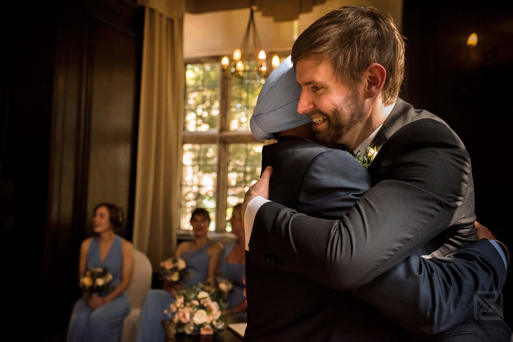 groom hugging a friend after signing of the register