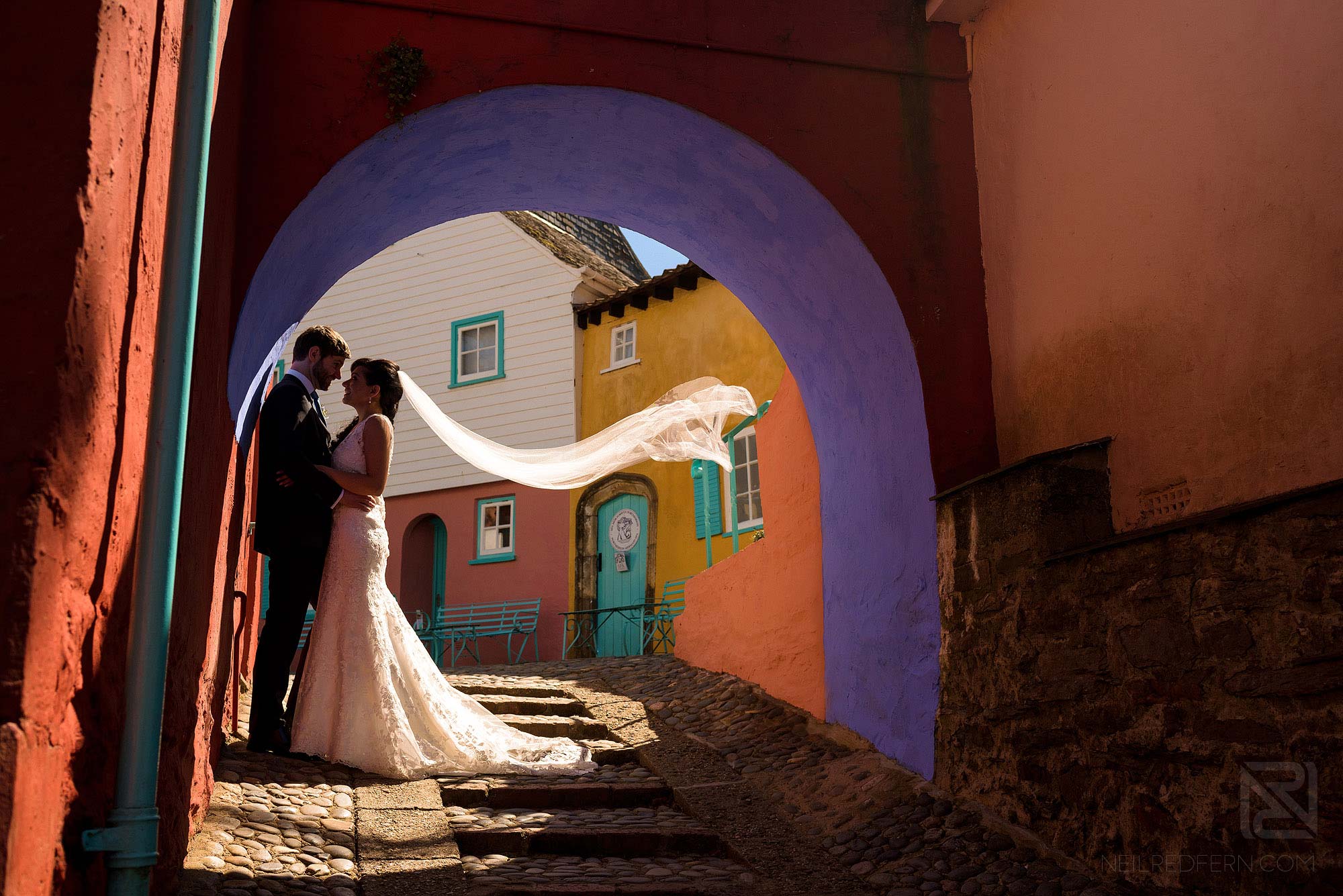 bride and groom portrait in Portmeirion with veil blowing in the wind