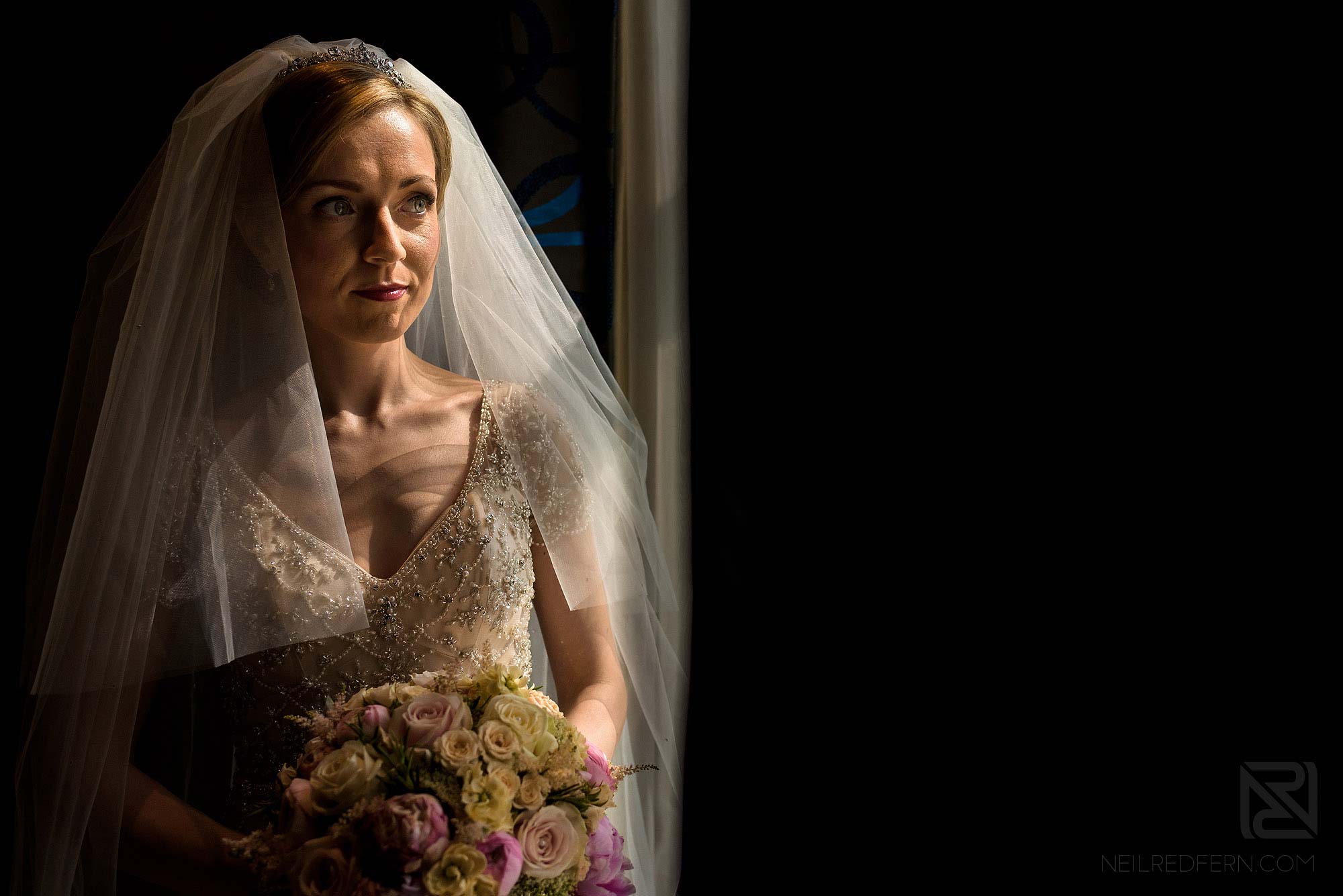 beautiful portrait of bride stood by window