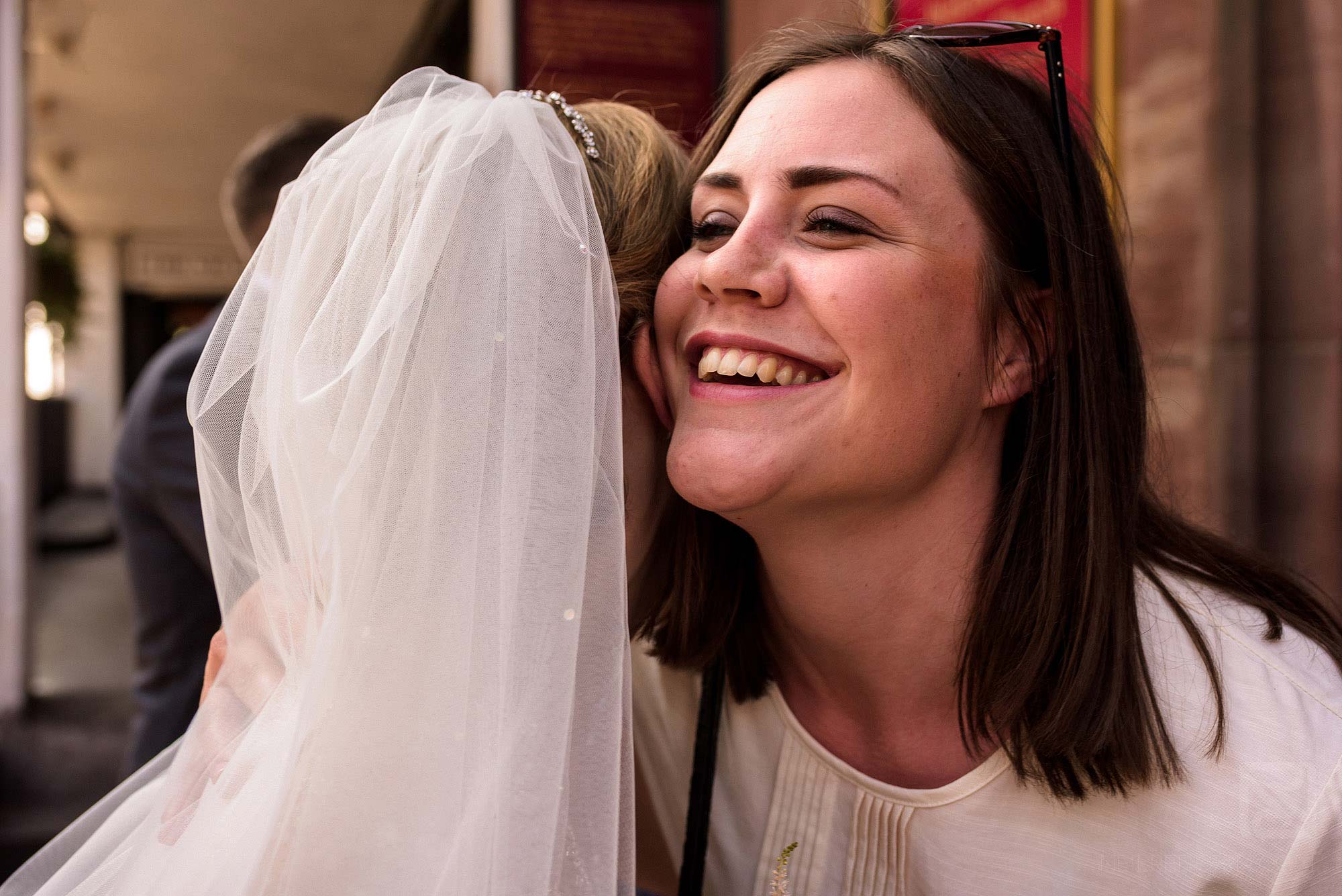 happy friend hugging bride on wedding day
